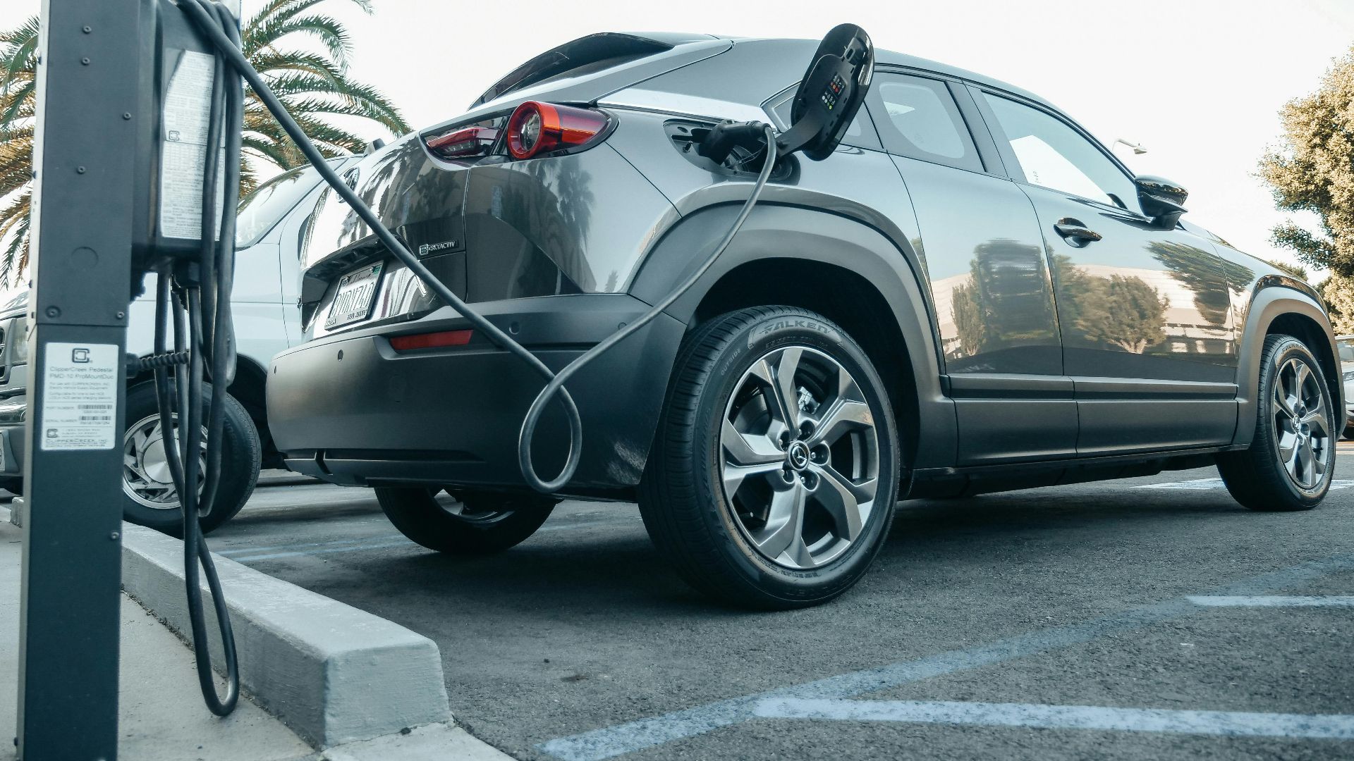 Modern electric vehicle charging at an outdoor station in daylight.