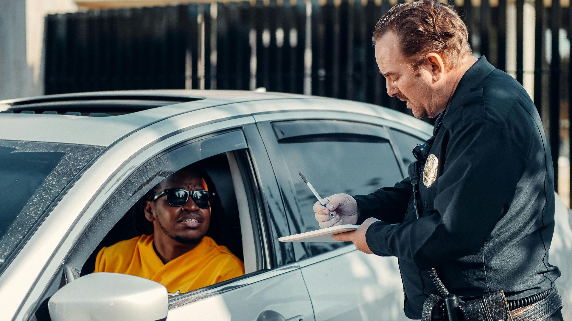Police officer writes a traffic ticket for a driver during a routine stop.
