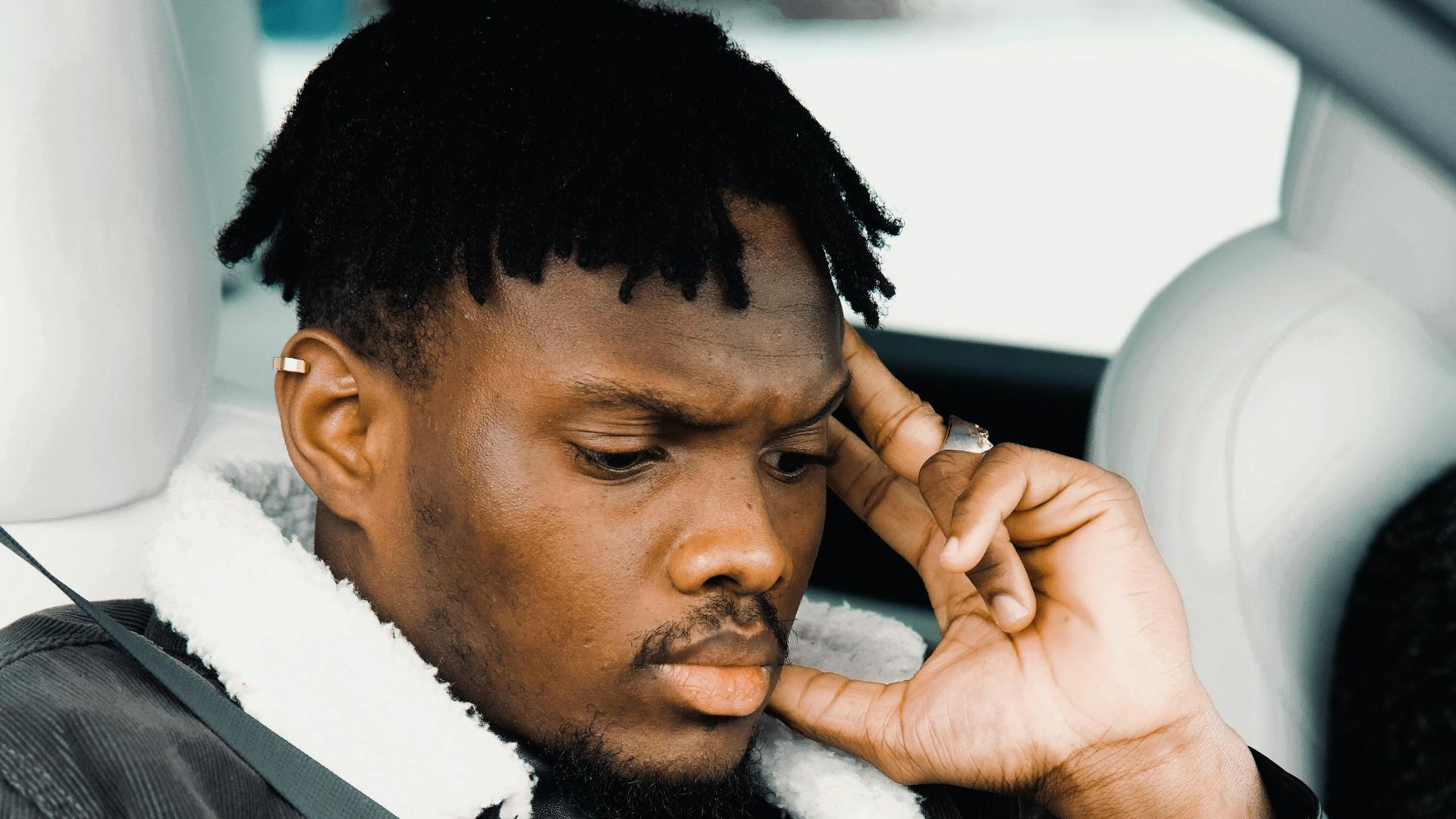 Pensive young man in a car seat, deep in thought in Montreal, Canada.