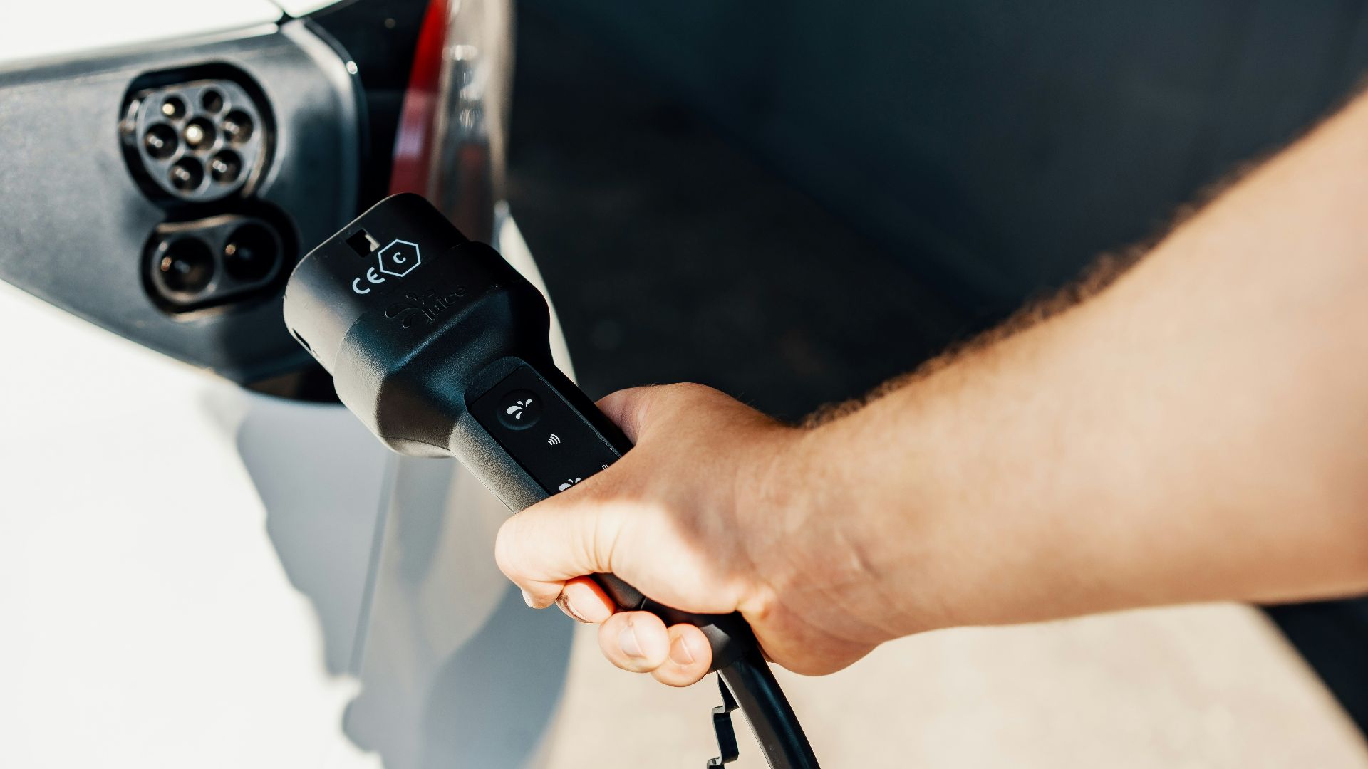 a person is plugging a car with a power cord