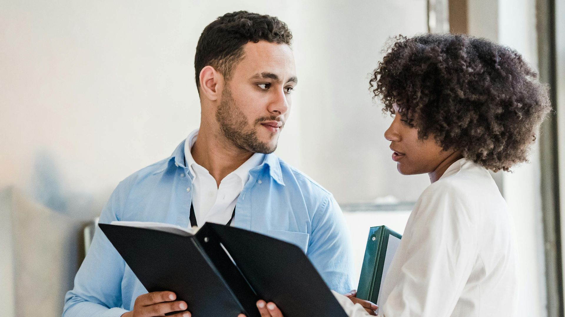 Business professionals discussing documents in a modern office setting.
