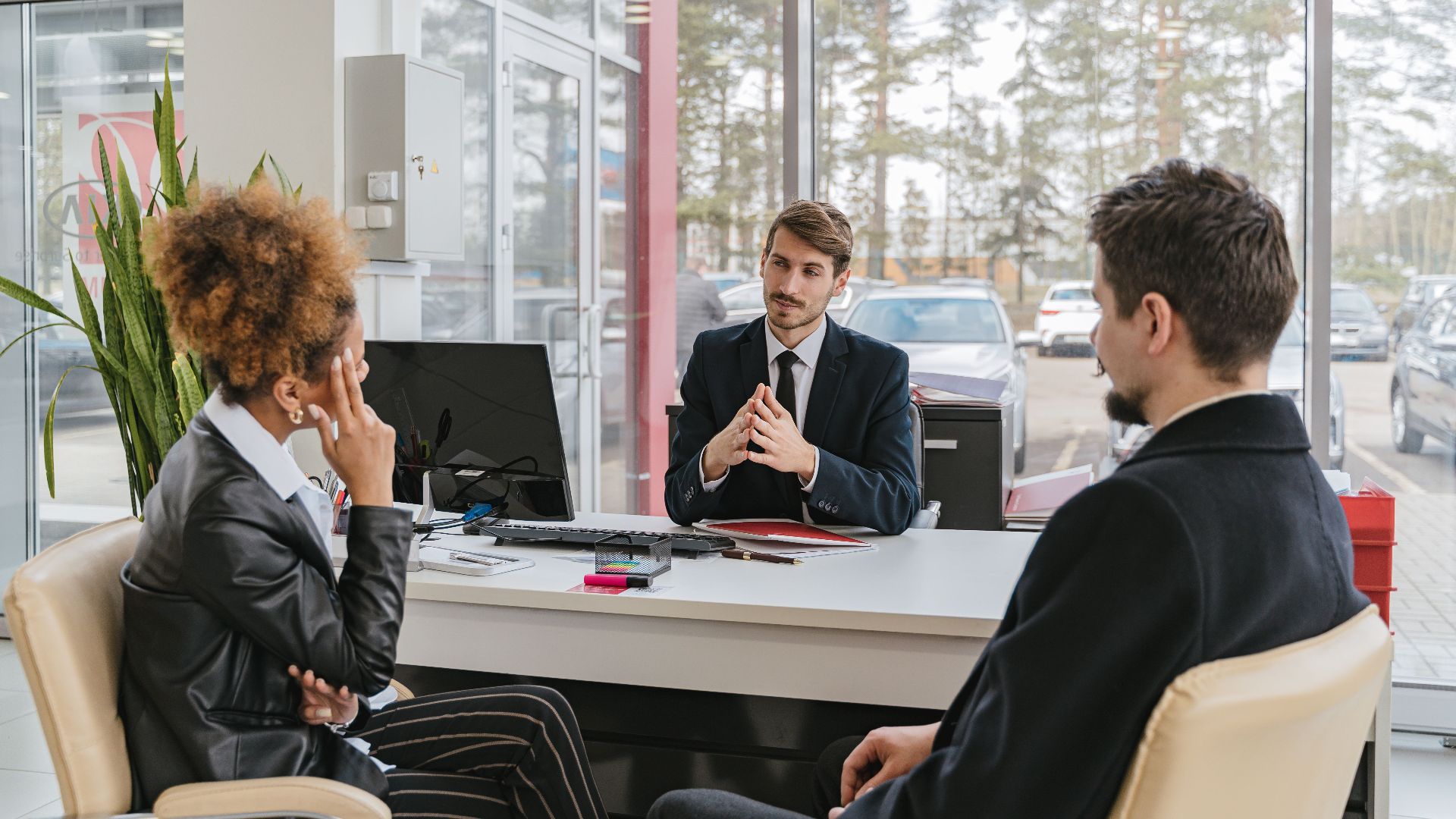 Three adults in a modern office setting having a professional business meeting.