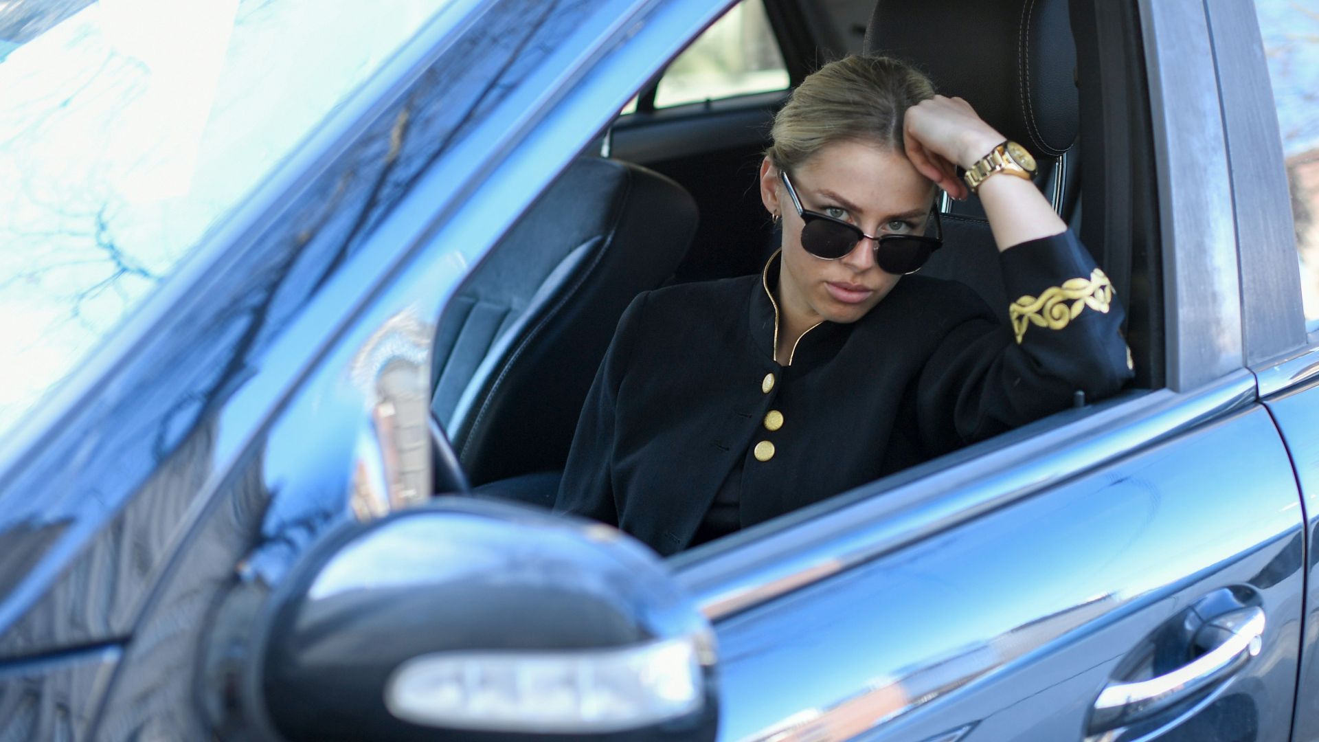 Woman in sunglasses sitting in a car
