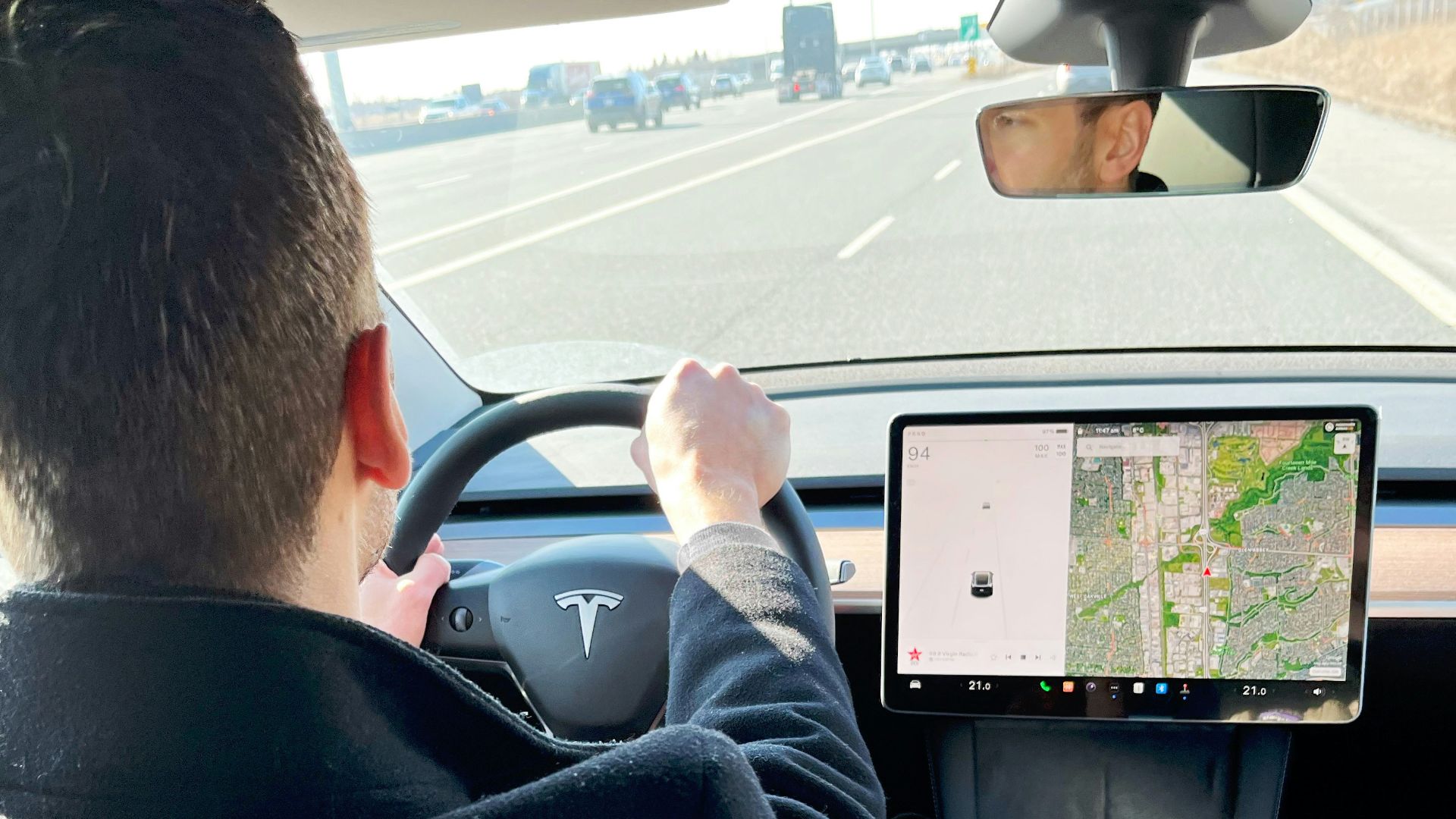 a man driving a car while holding a tablet