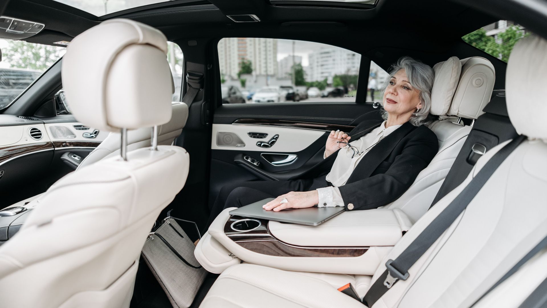 Senior woman relaxing in a luxurious car interior, enjoying the comfort and modern design.