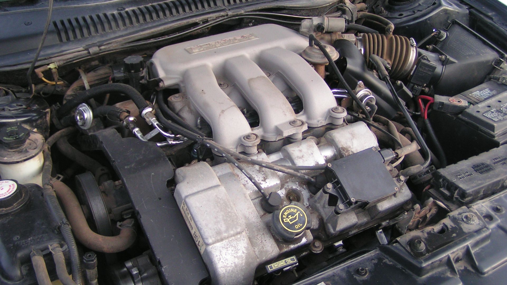 A 3.0L DOHC Duratec V6 engine tightly packed into a 1998 Ford Taurus.