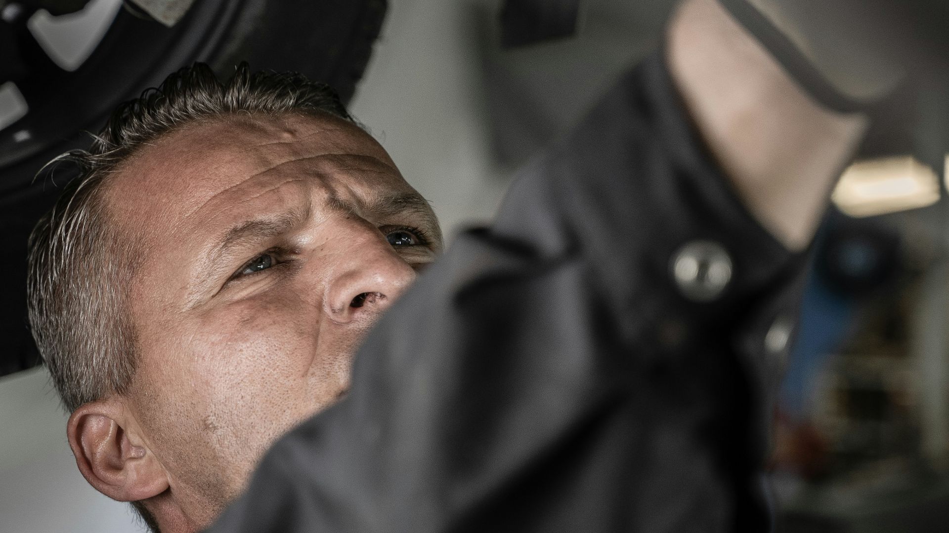 a man working on a car under a vehicle