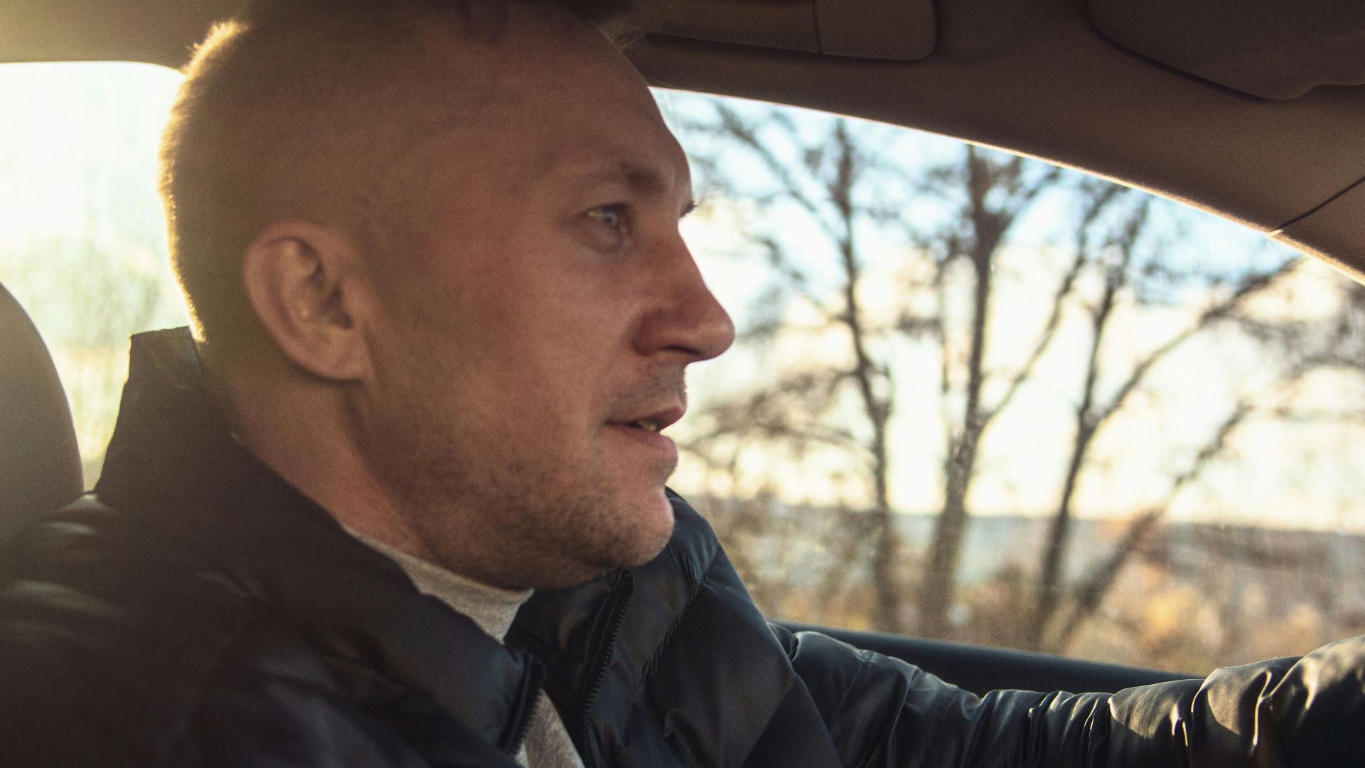 Man driving a car on a sunny day.