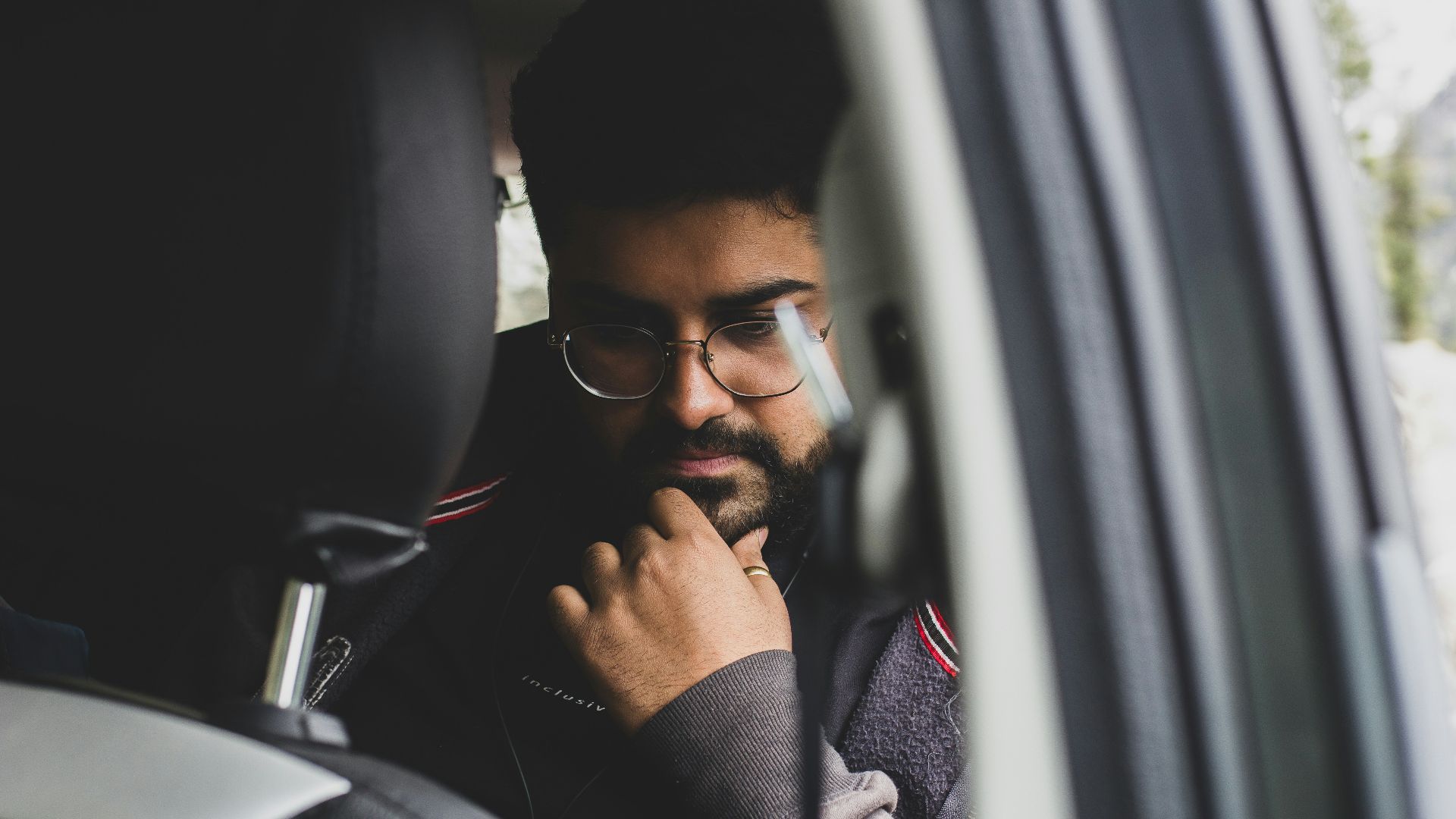 a man sitting in a car looking out the window