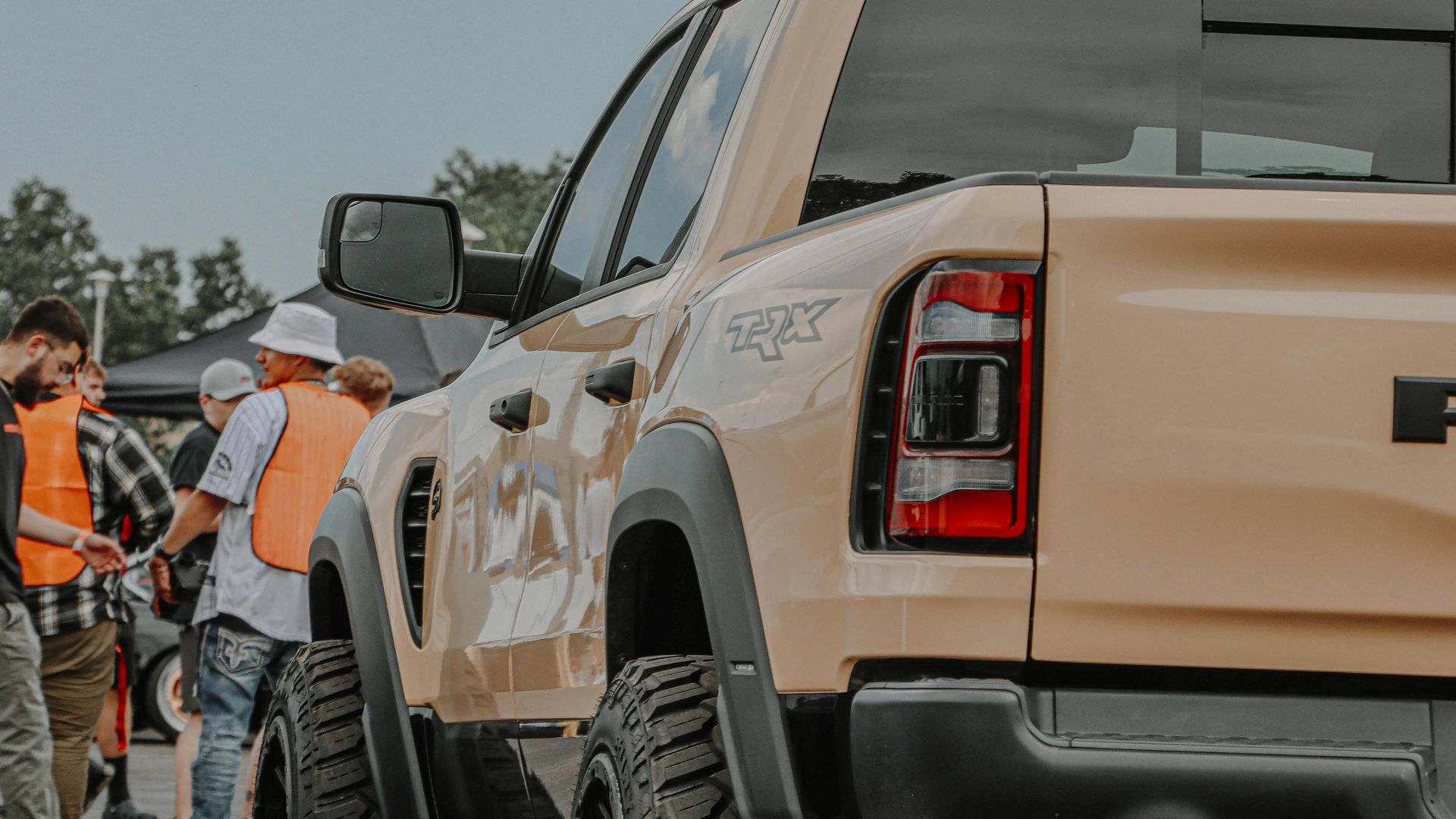 A rugged pickup truck showcased at a bustling outdoor automotive event.