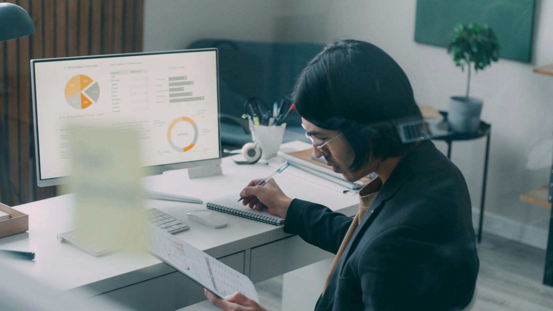 Business person reviewing analytics and charts at a modern office desk.