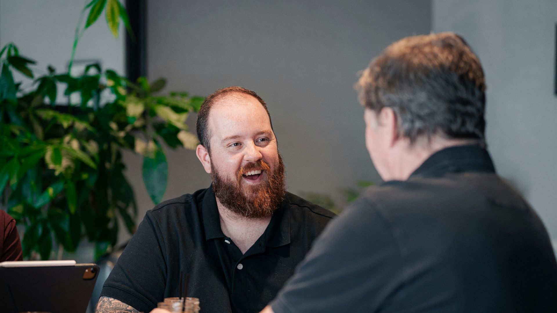 two men sitting at a table talking to each other