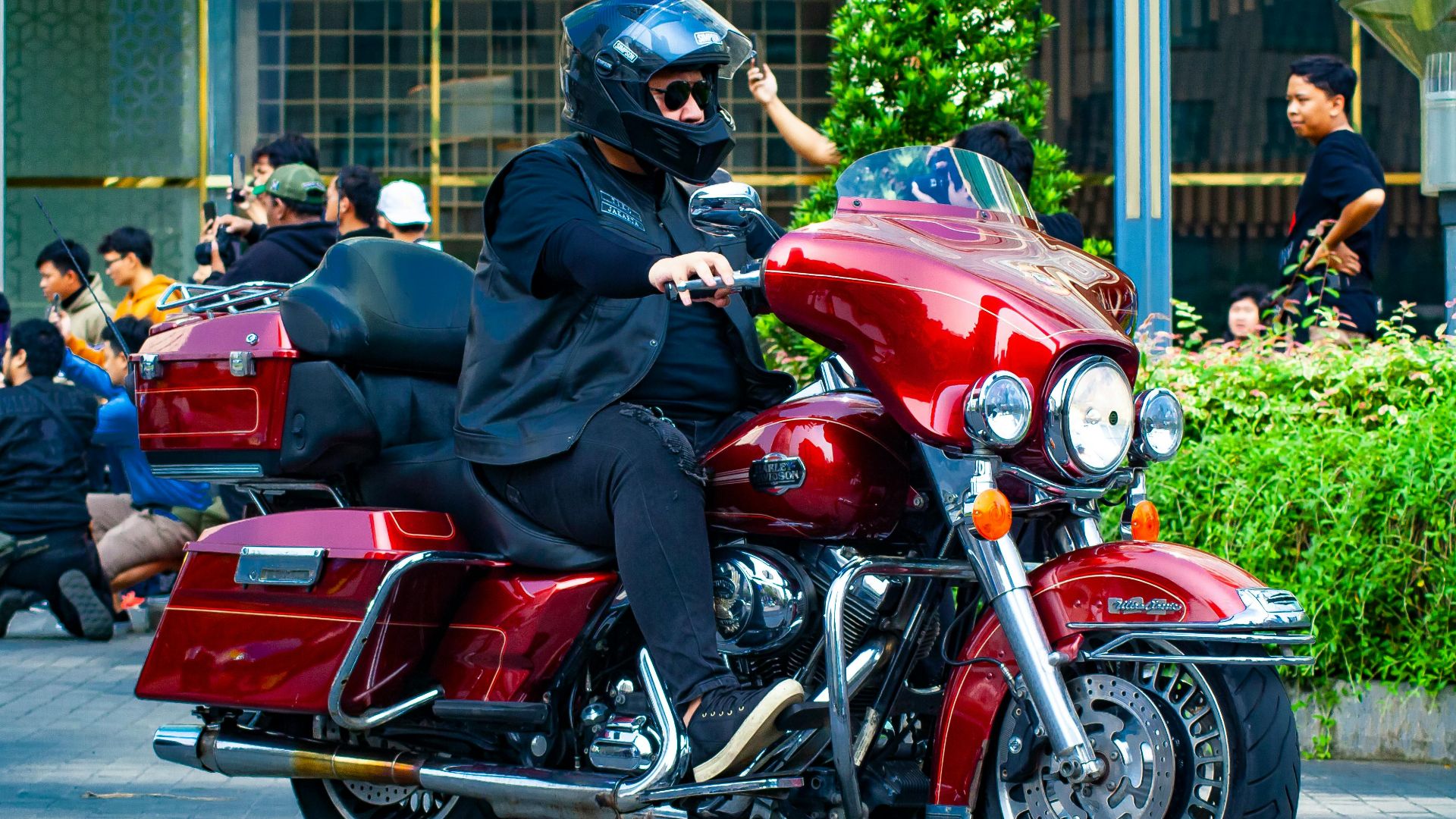 A biker on a Harley Davidson Ultra CVO riding through city streets in Indonesia.