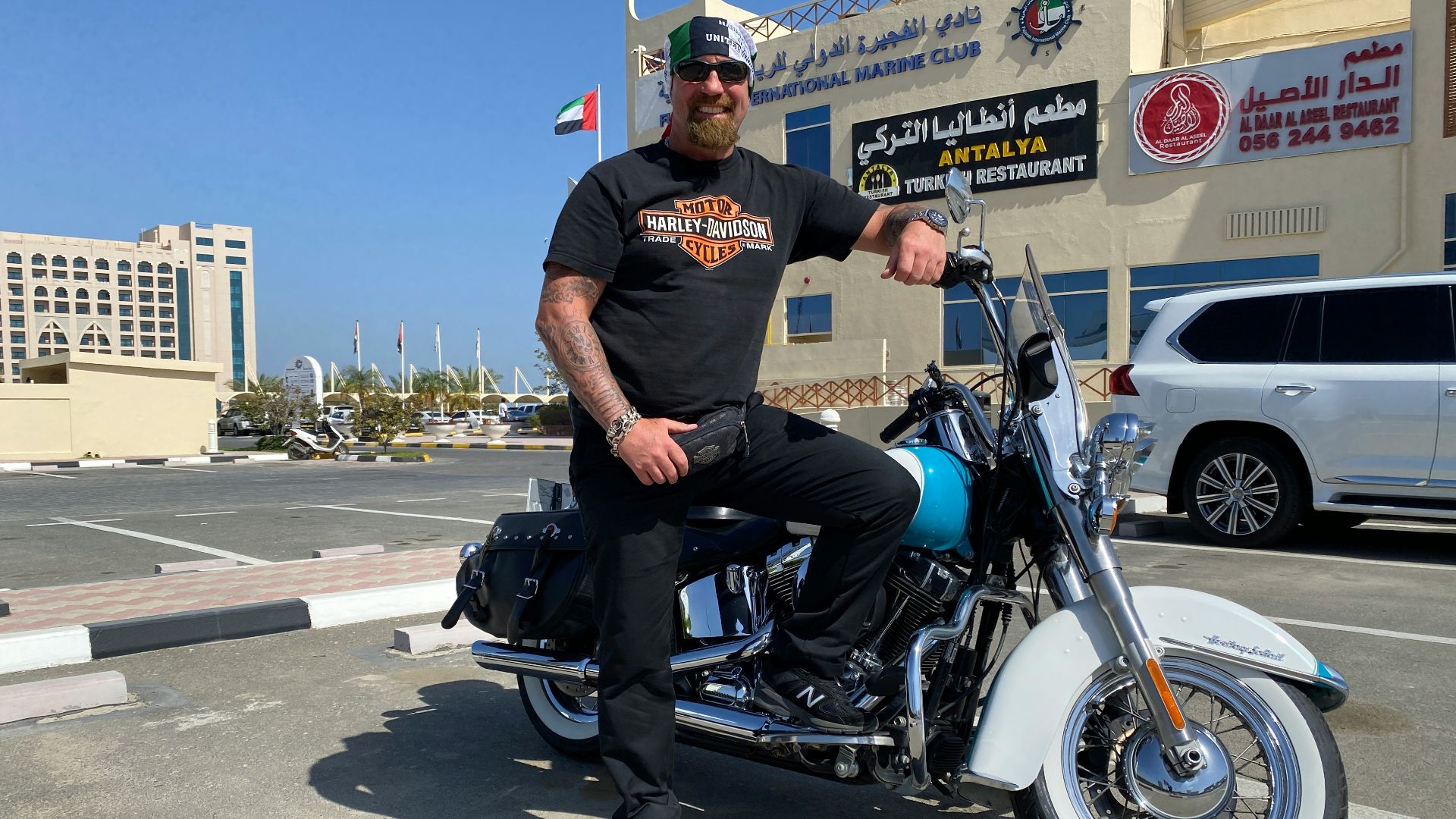 a man sitting on a motorcycle in a parking lot
