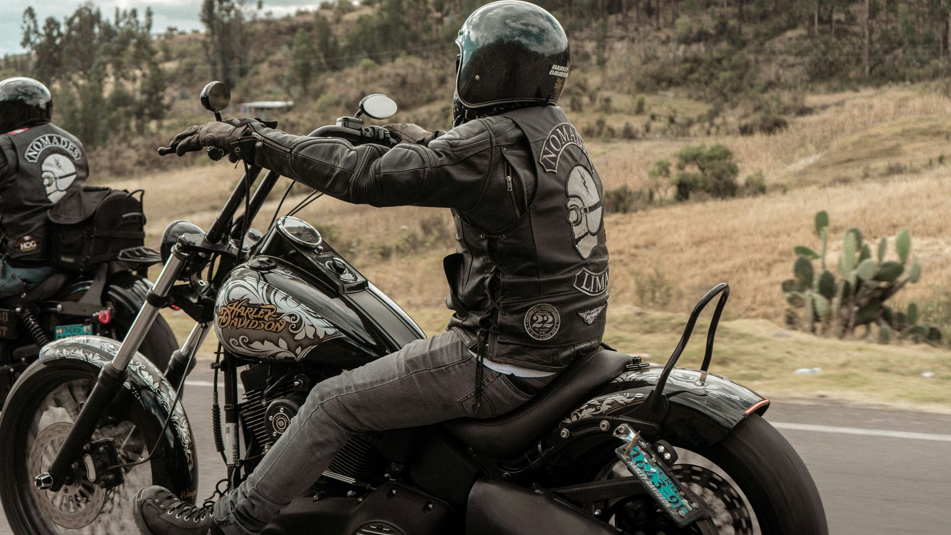 two people riding motorcycles on a road