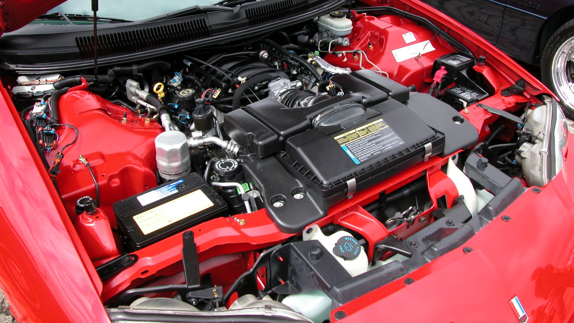 This is an image of GM's stock 5.7L LS1 V8 engine that outputs 305hp. This is from my 1998 Chevrolet Camaro Z28 and was taken during the 2003 Super Chevy Show in Pomona, CA. The camera used is a Nikon Coolpix 5000.