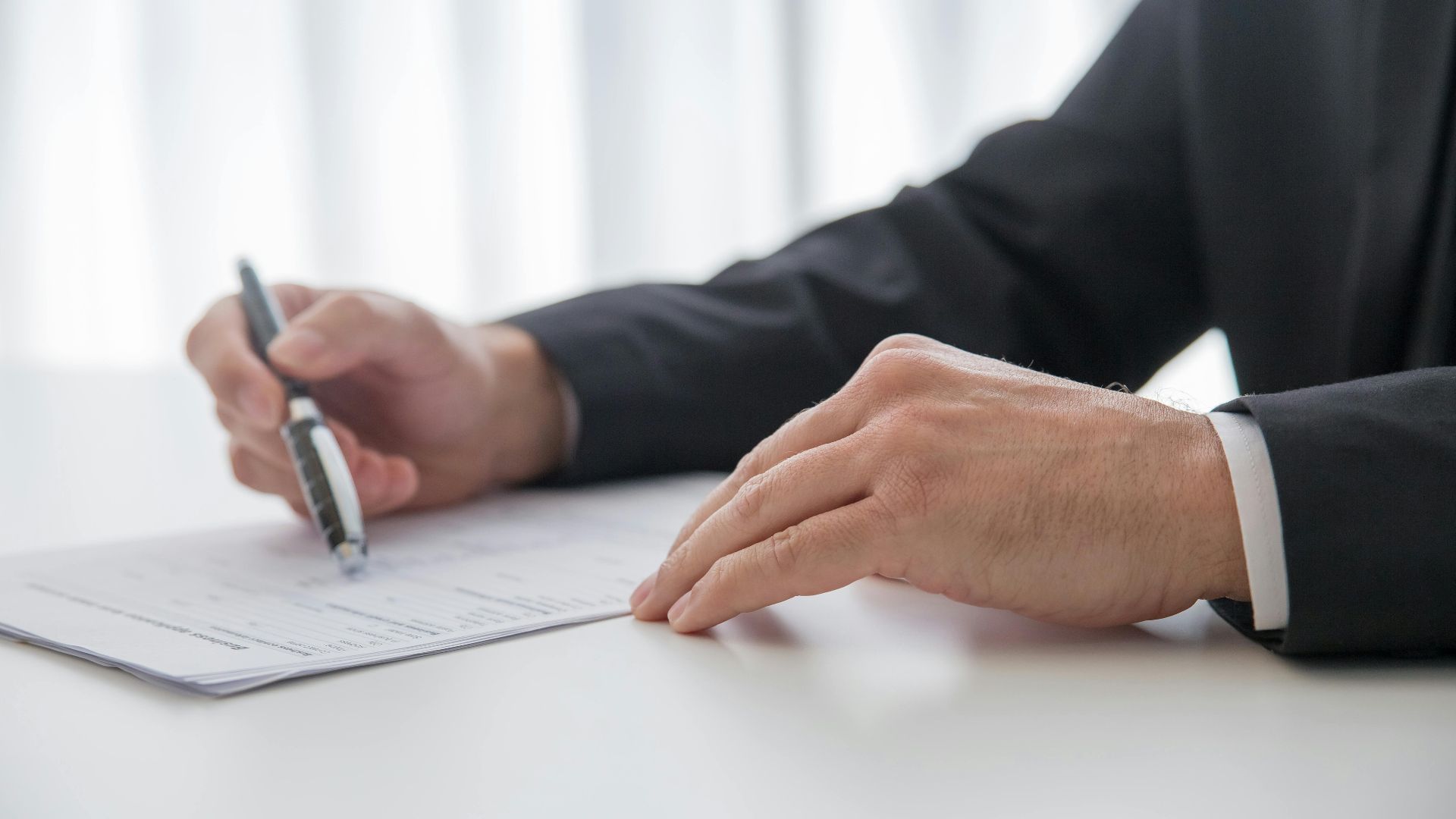 Businessman signing important documents at office desk.