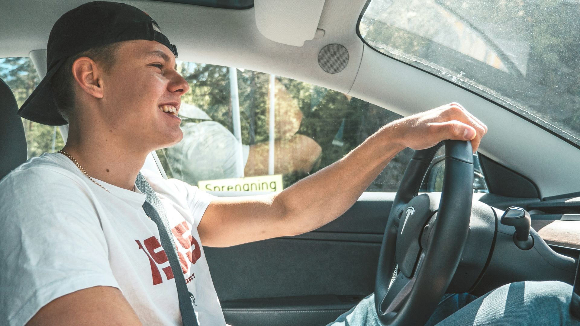 man in white crew neck t-shirt driving car