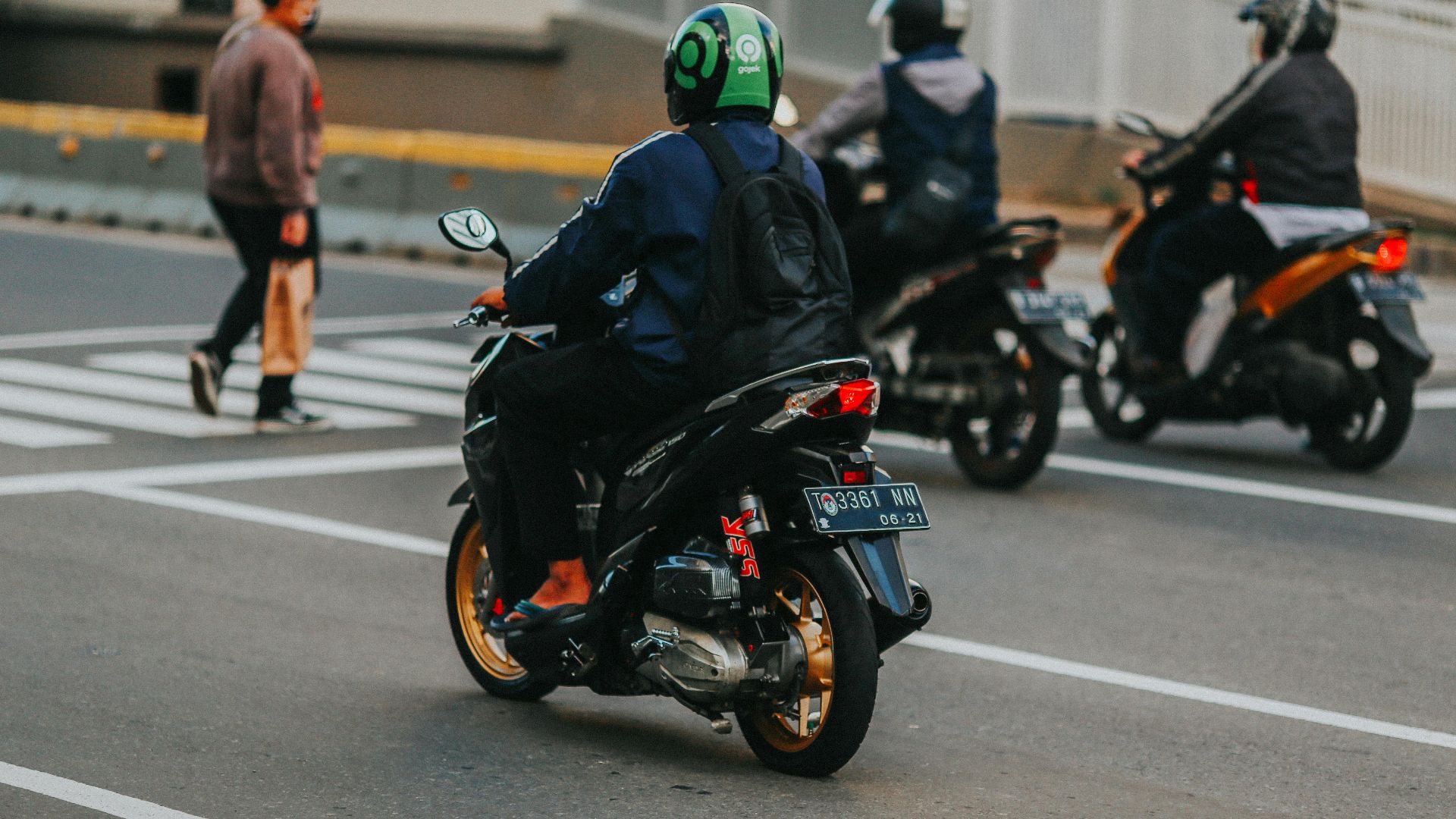 A group of motorcyclists navigating Jakarta's busy streets, showcasing urban commuting.