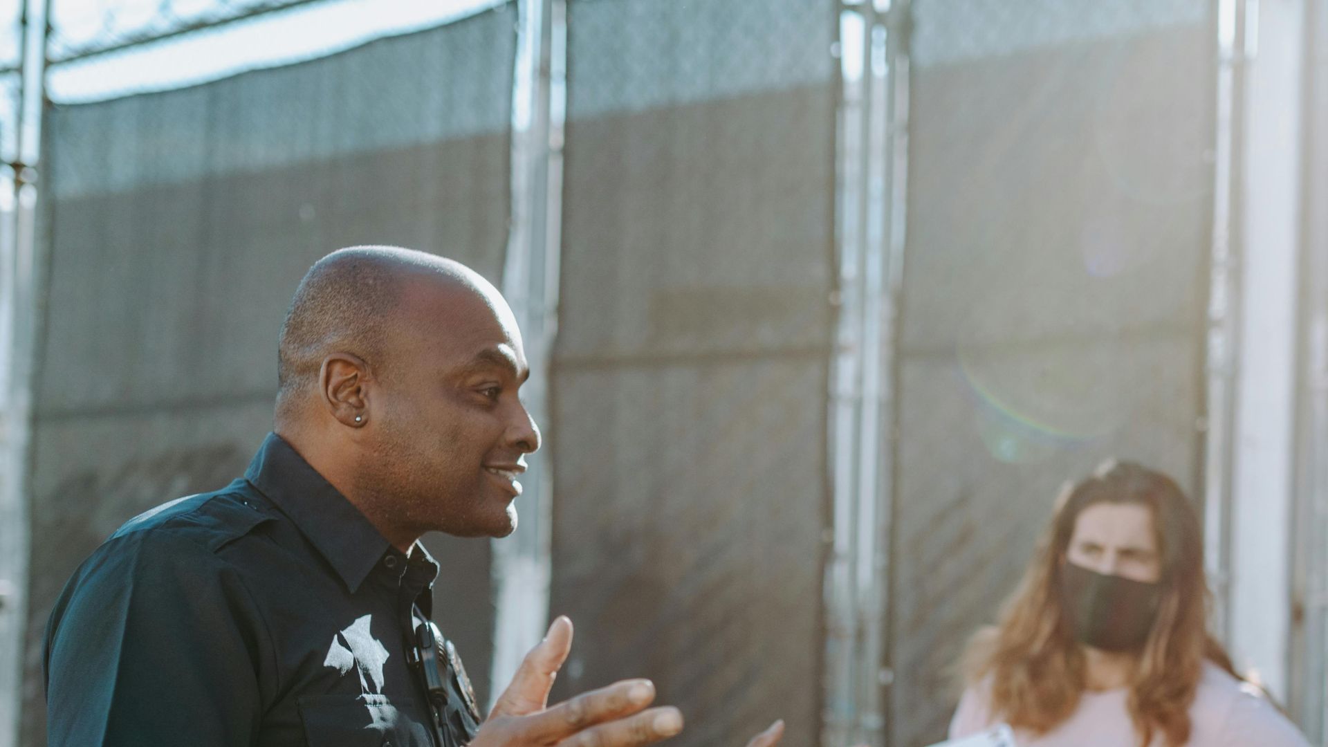 A police officer converses with protesters holding signs outdoors, demonstrating active communication.