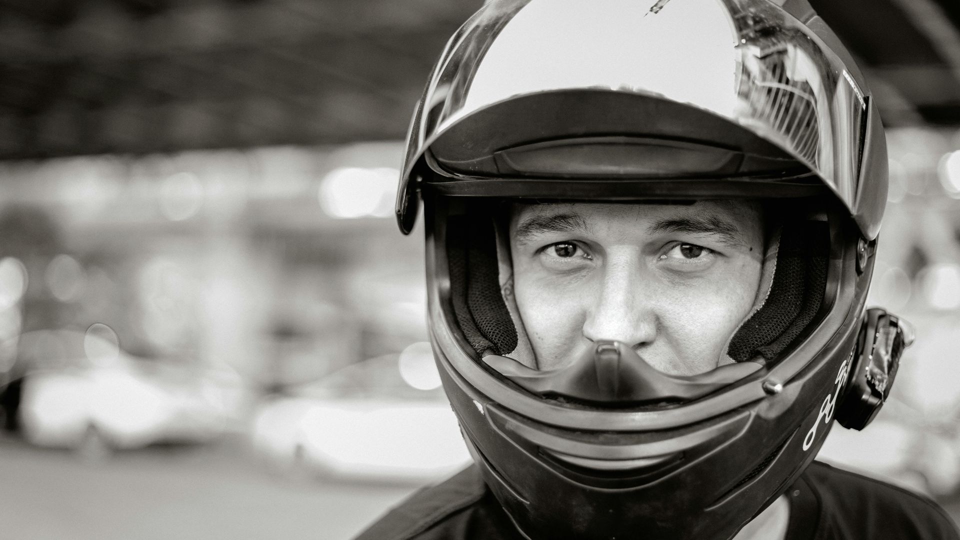Monochrome close-up of a man wearing a helmet, offering a focused and intense expression.