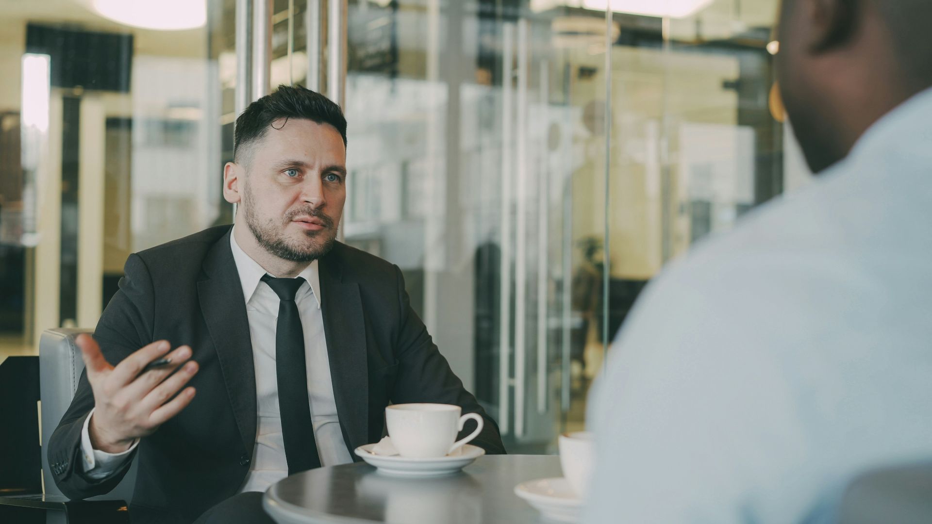 Two men in suits talking at a table