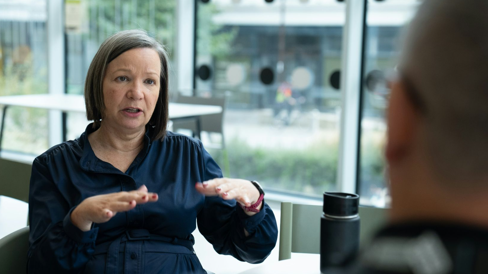 Woman gesturing while talking to person