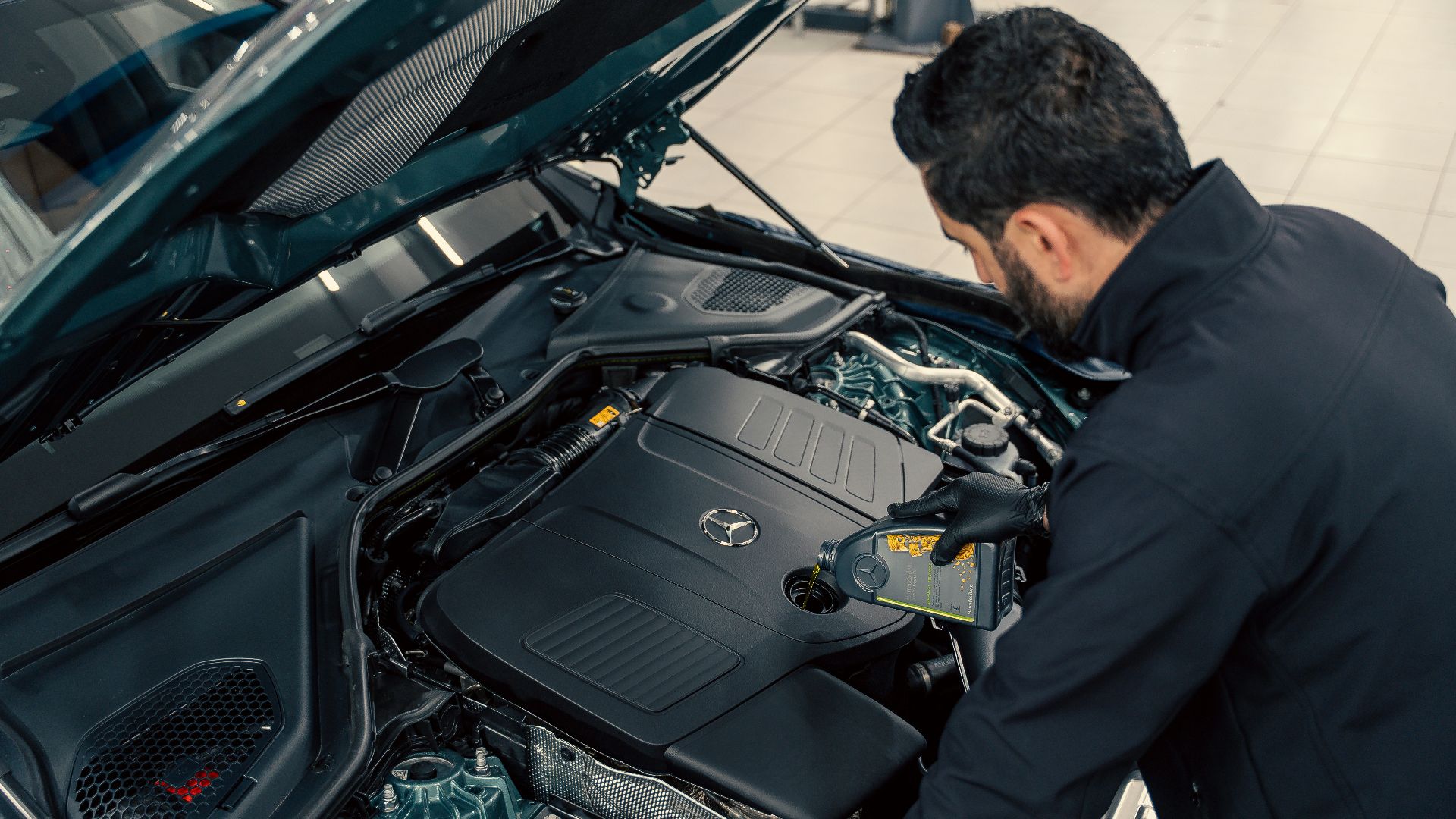 Mechanic inspecting a car engine with hood open