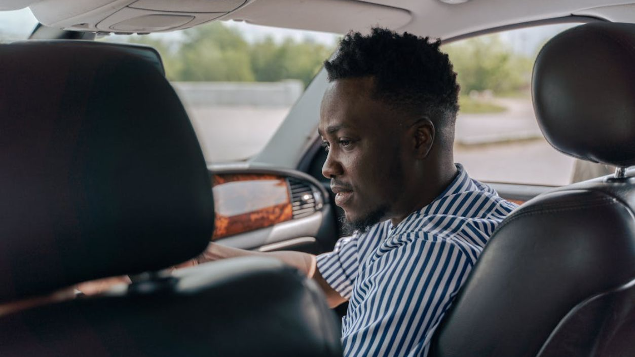 Man in White and Blue Striped Dress Shirt Driving Car