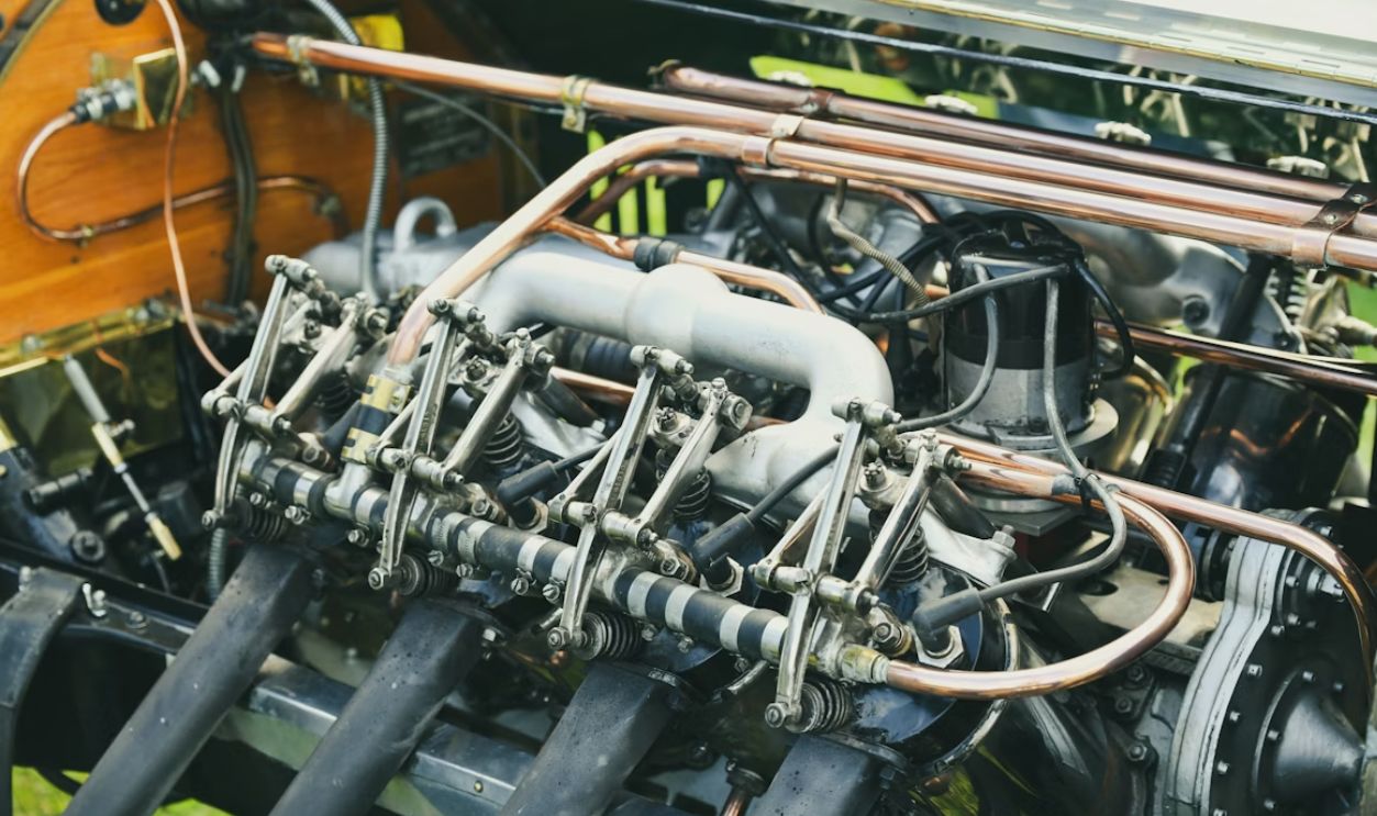 Close-up of a vintage car engine with copper pipes.