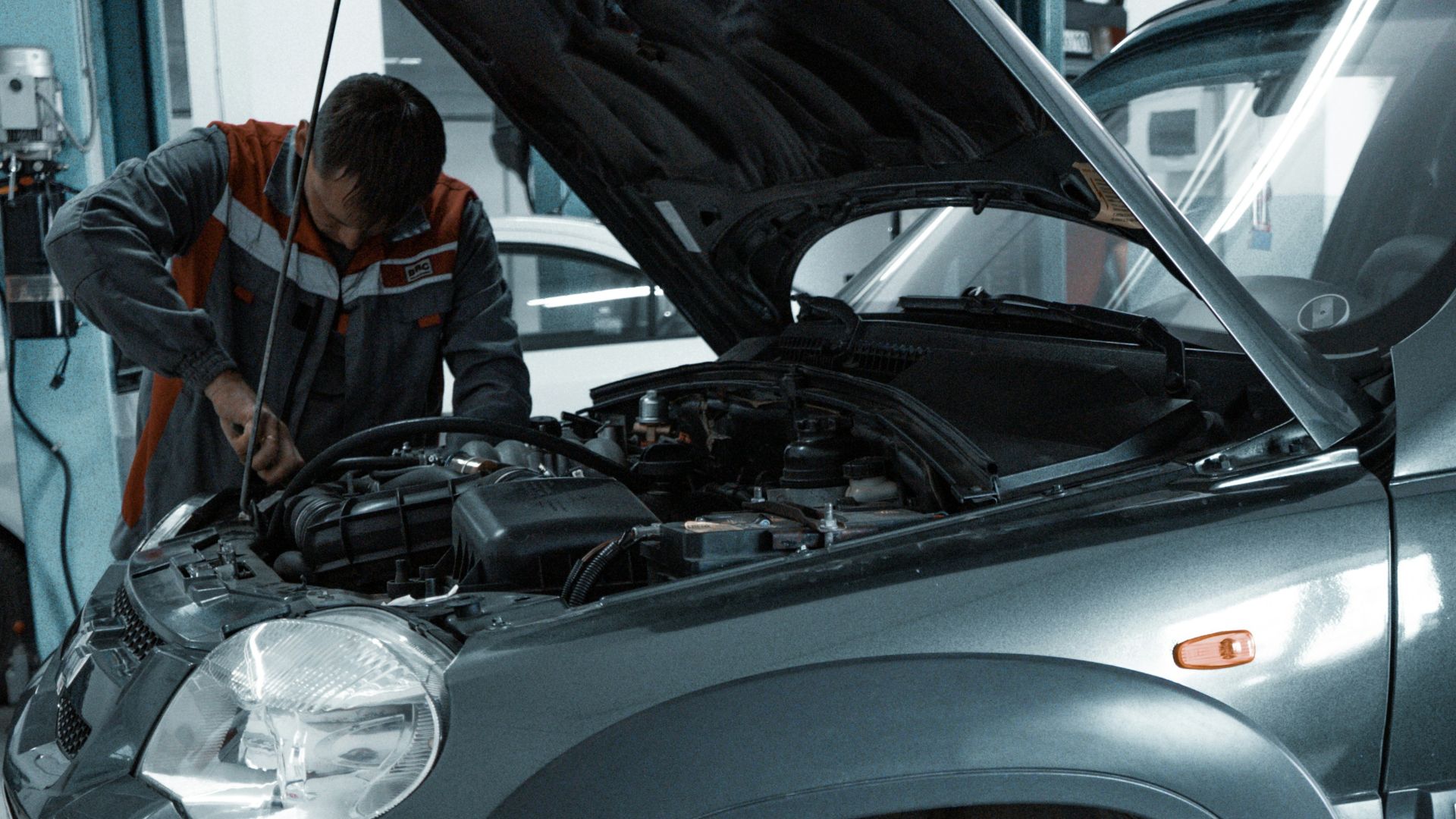 man in black jacket standing beside black car