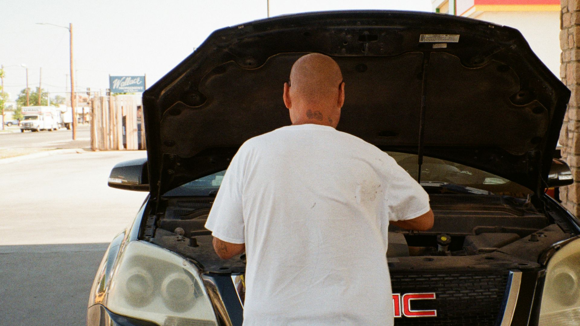 A man standing next to a car with its hood open