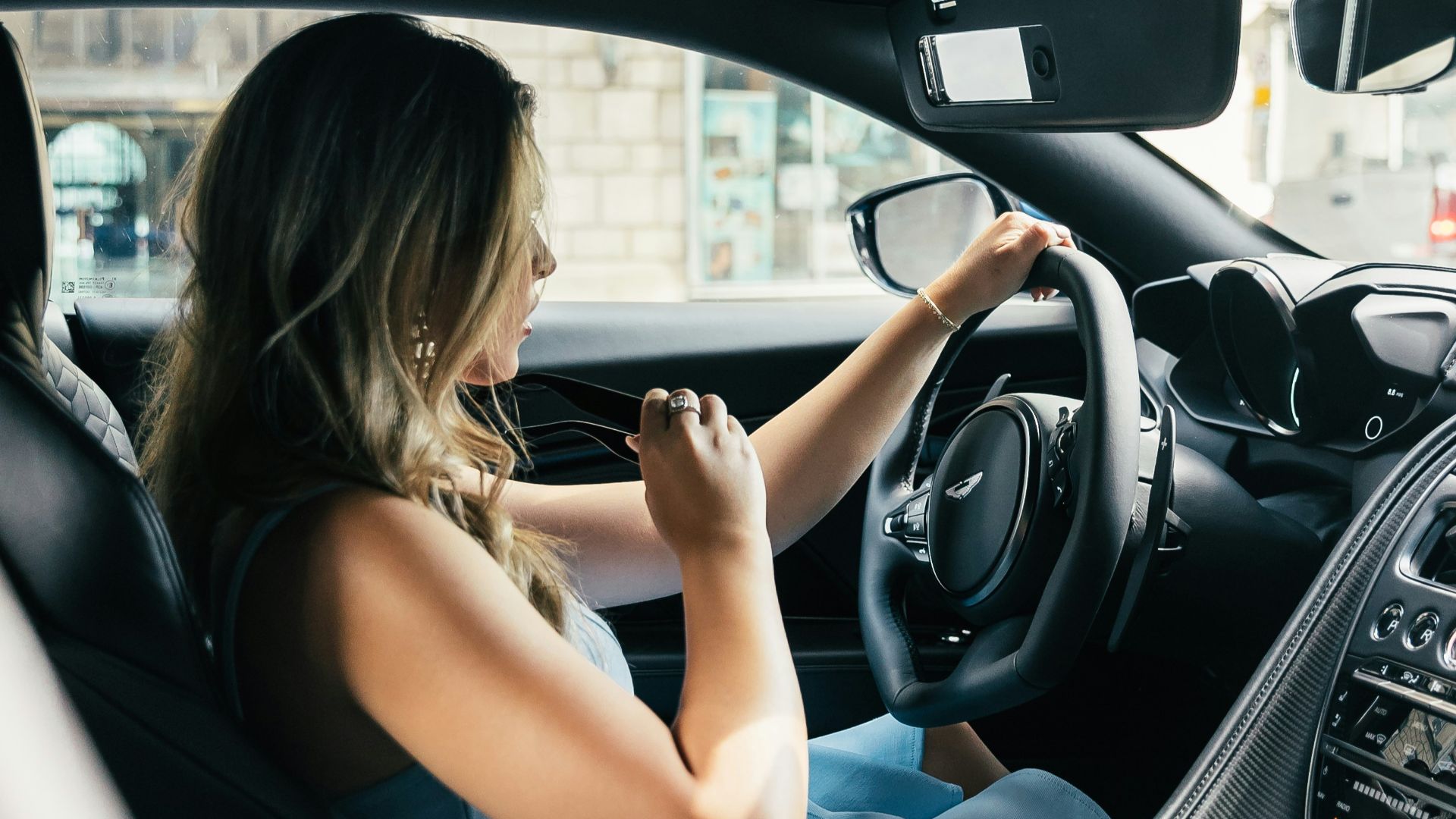 woman wearing white tank top driving vehicle during daytime