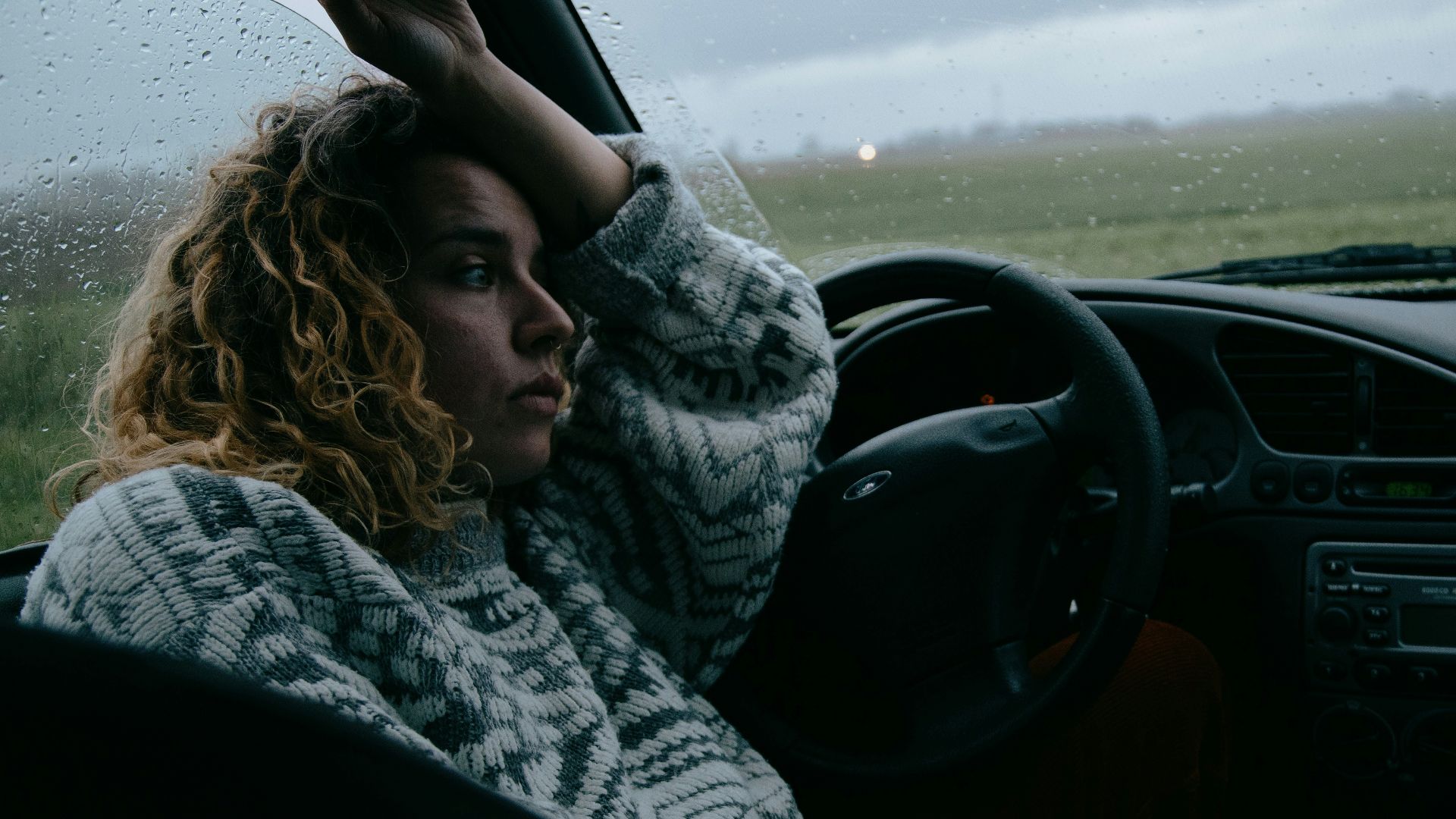 woman in black and white scarf driving car