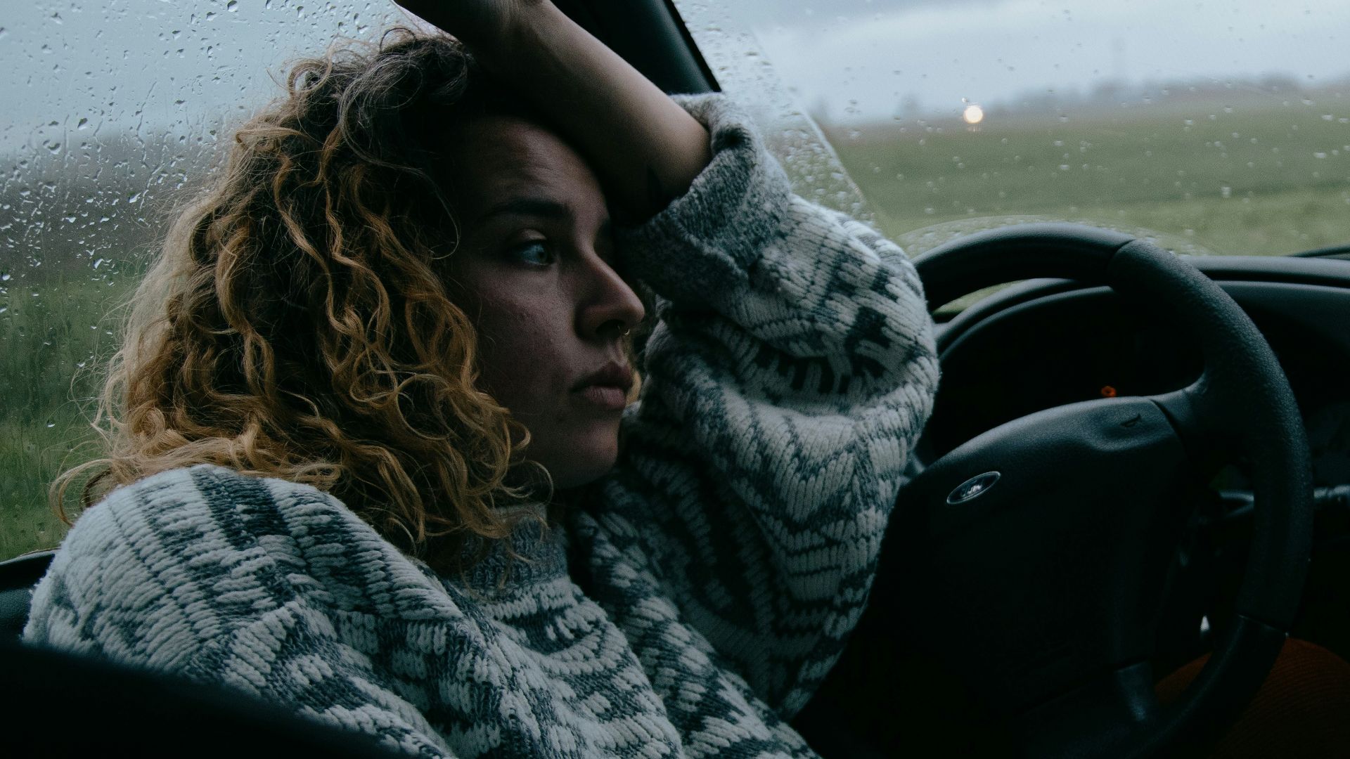 woman in black and white scarf driving car
