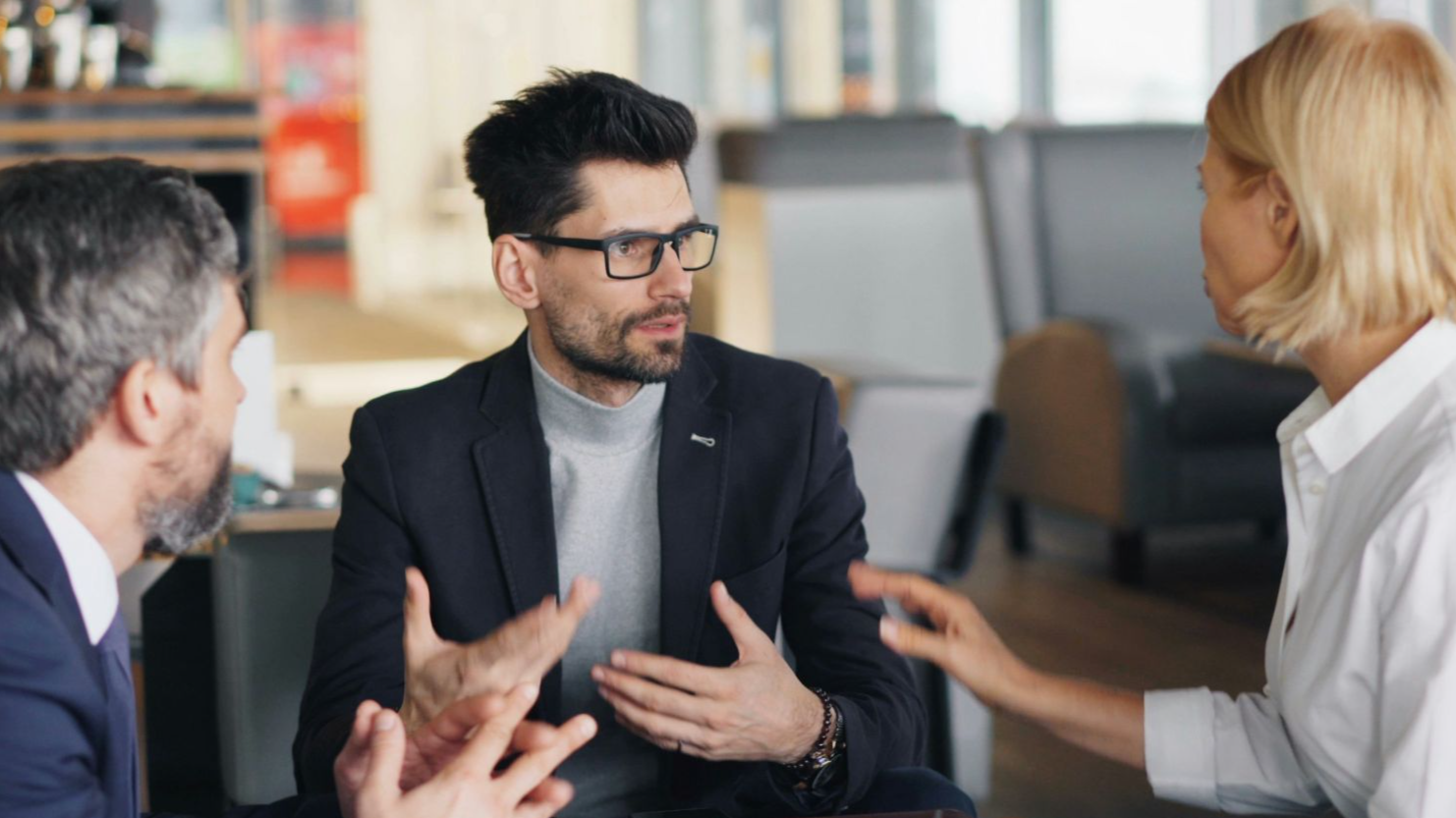 a group of people sitting around a table talking
