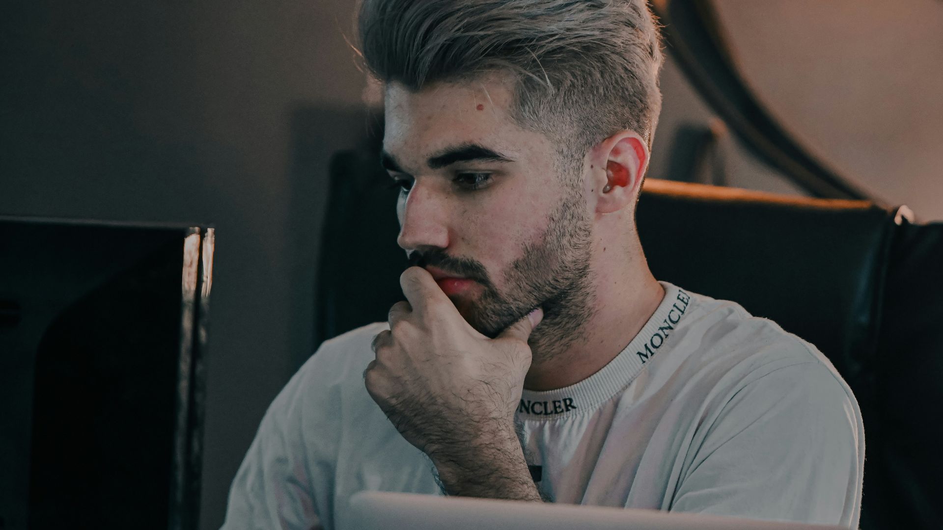 a man with a beard looking at a laptop