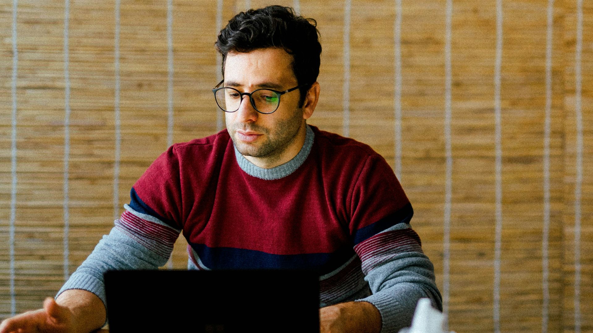 a man sitting in front of a laptop computer