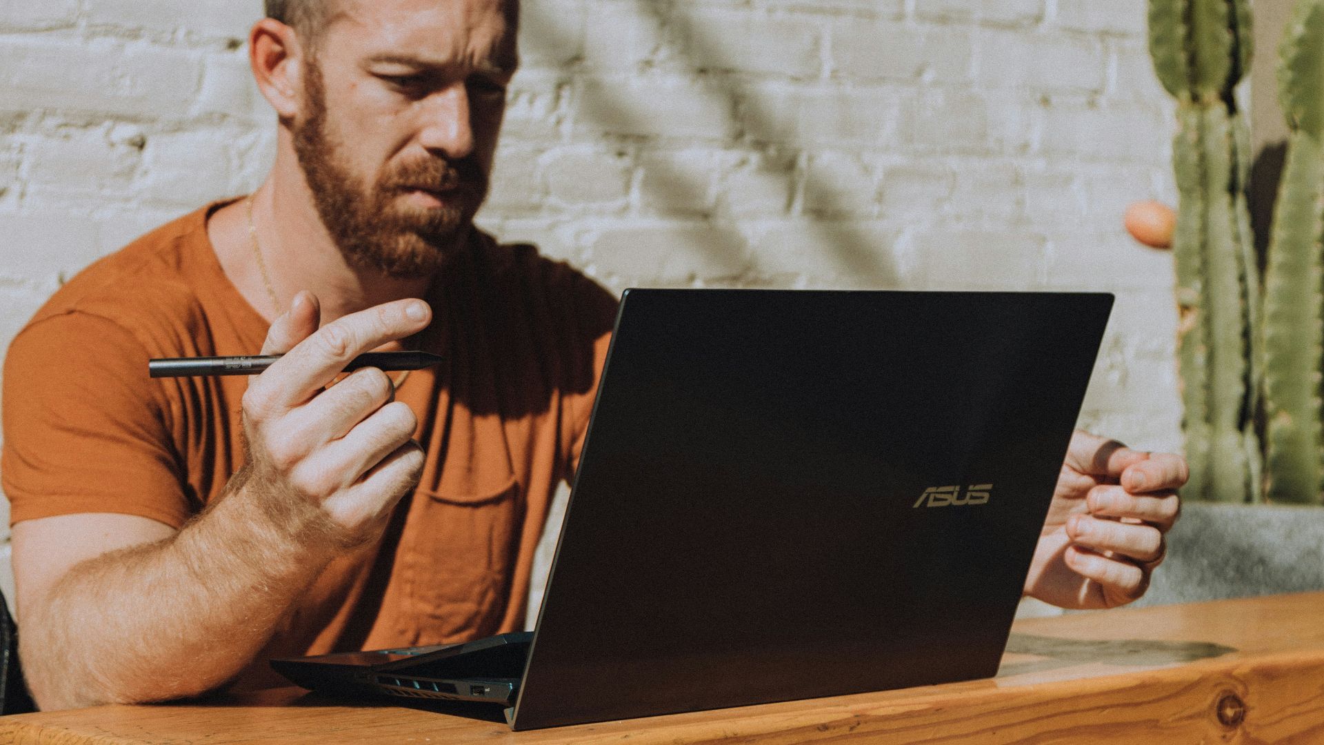 a man sitting at a table using a laptop computer