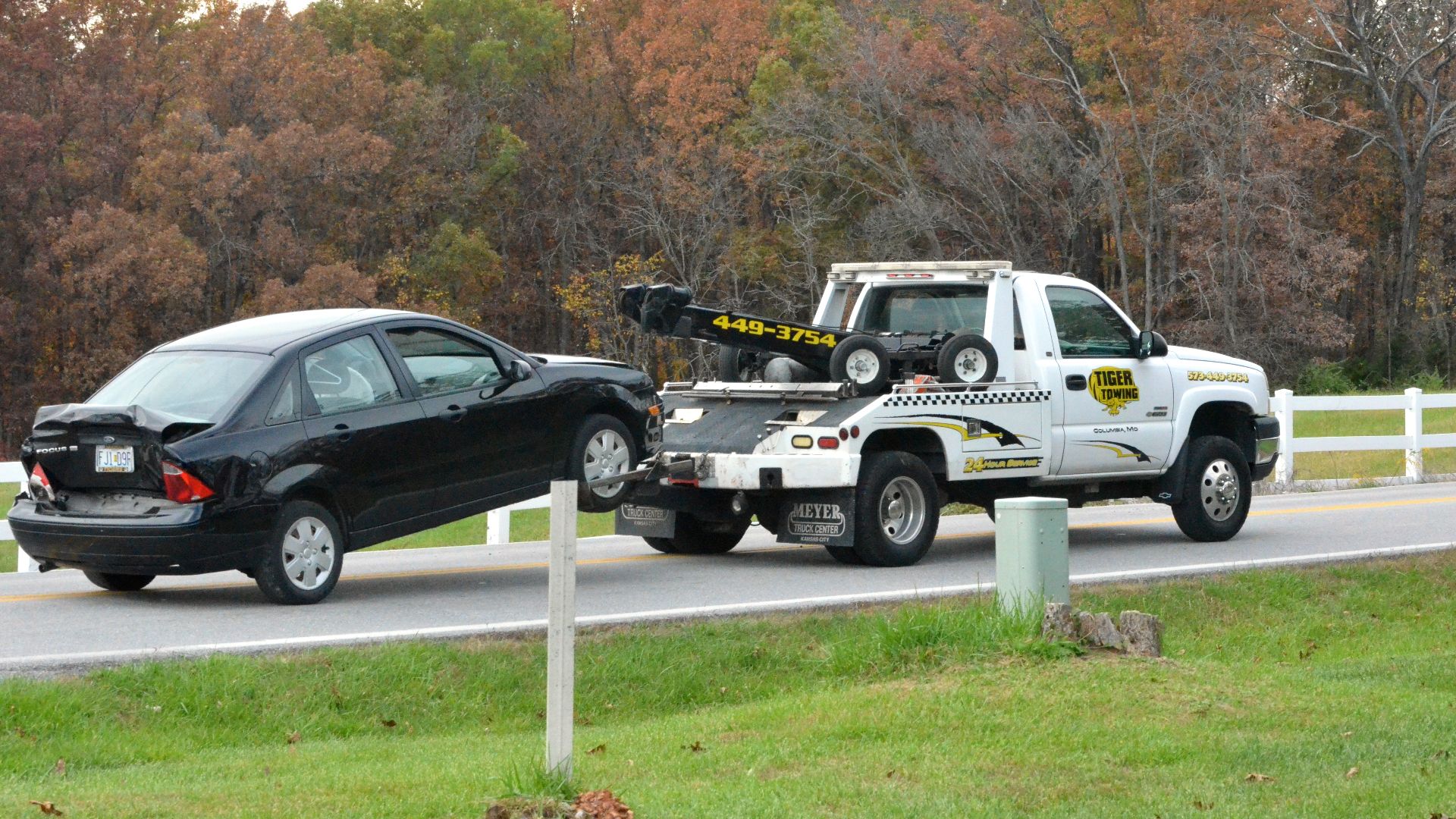 A Tiger Towing truck drives away with a black Ford Focus after an accident on Rock Quarry Road in Columbia, Missouri on Tuesday Oct. 28, 2014. Rock Quarry Road was temporarily closed to traffic due to the accident.