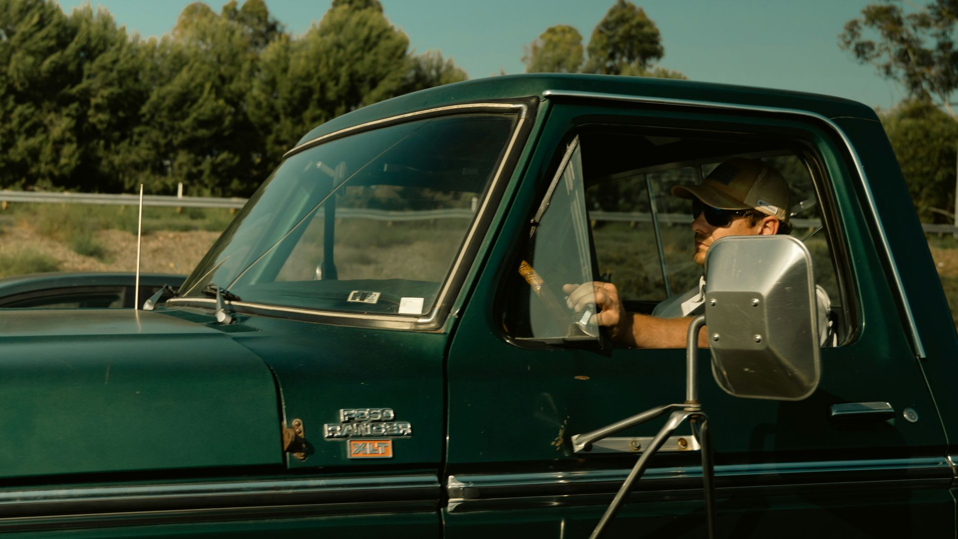 Man driving a green vintage pickup truck