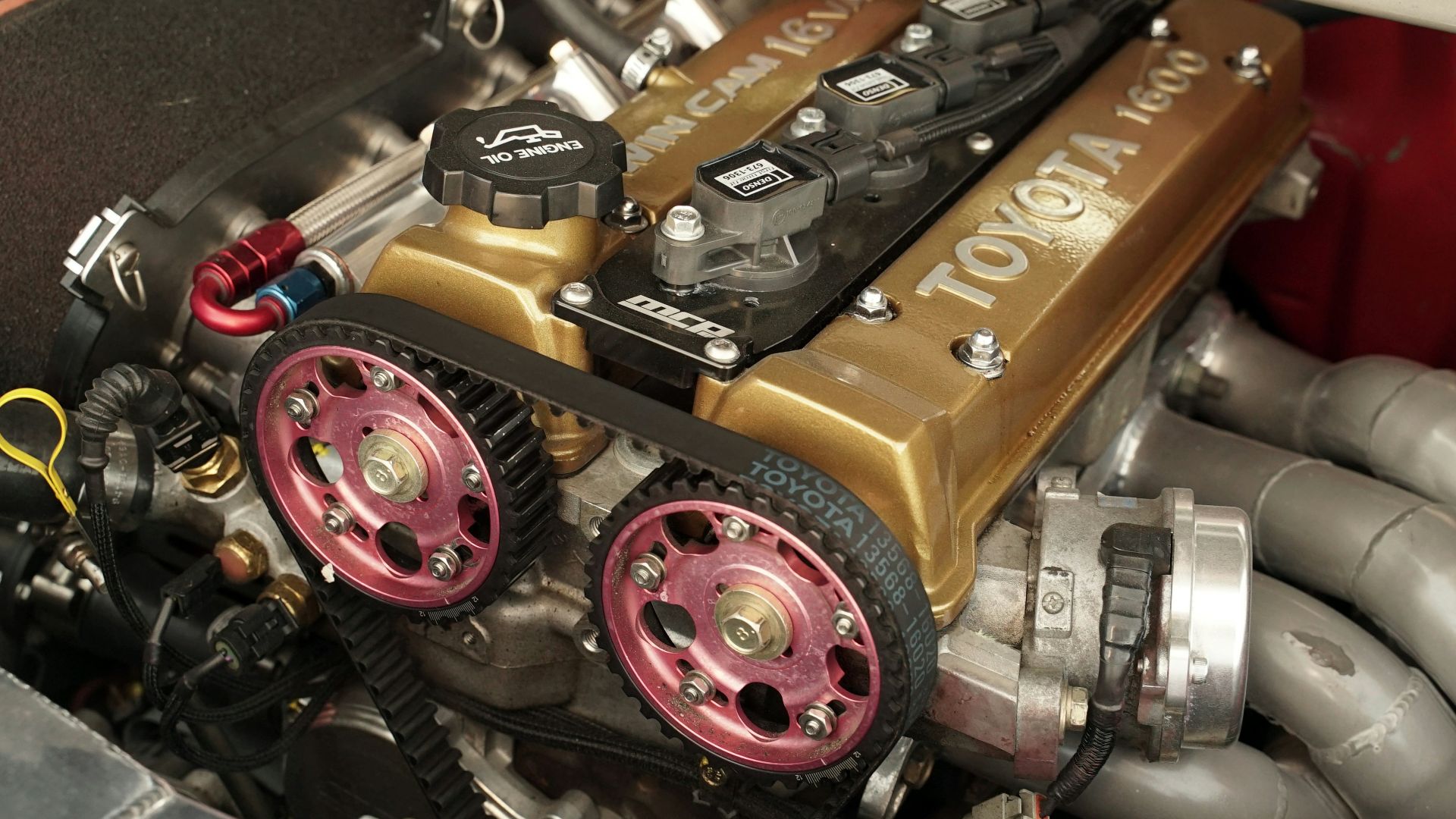 Close-up of a modified toyota engine with gold valve cover.