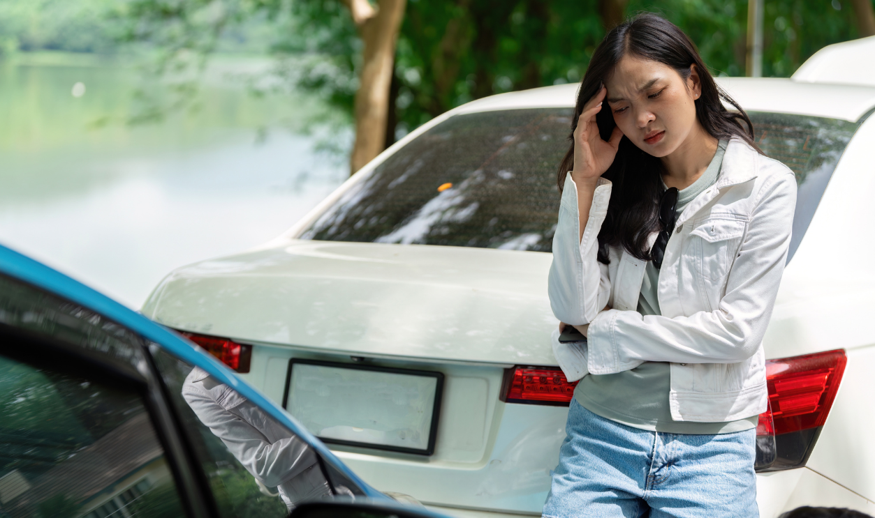Insurance Stress. A woman looking worried after a car accident, waiting for assistance.