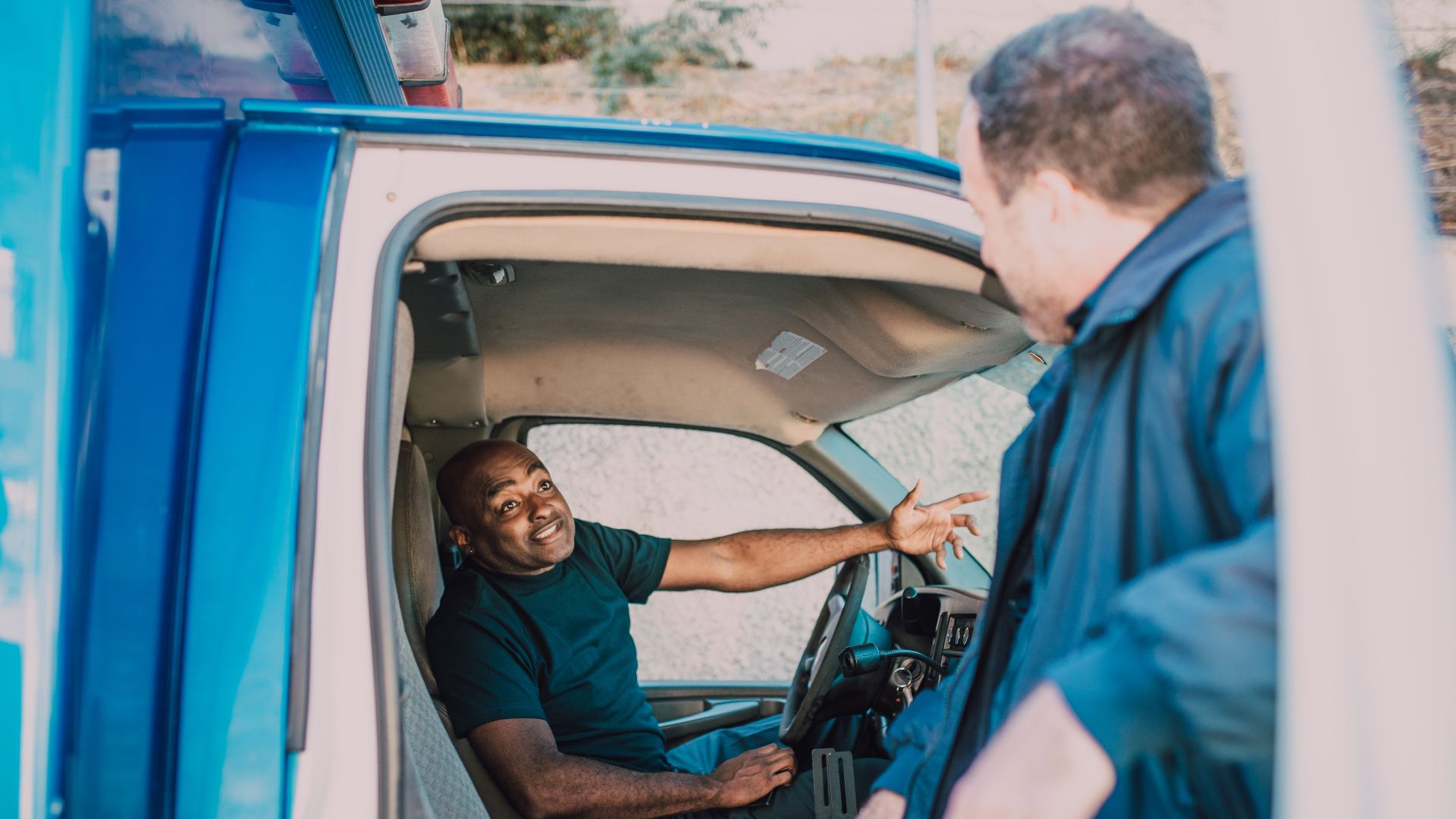 Emergency medical technicians engaged in conversation while preparing for duty in an ambulance.