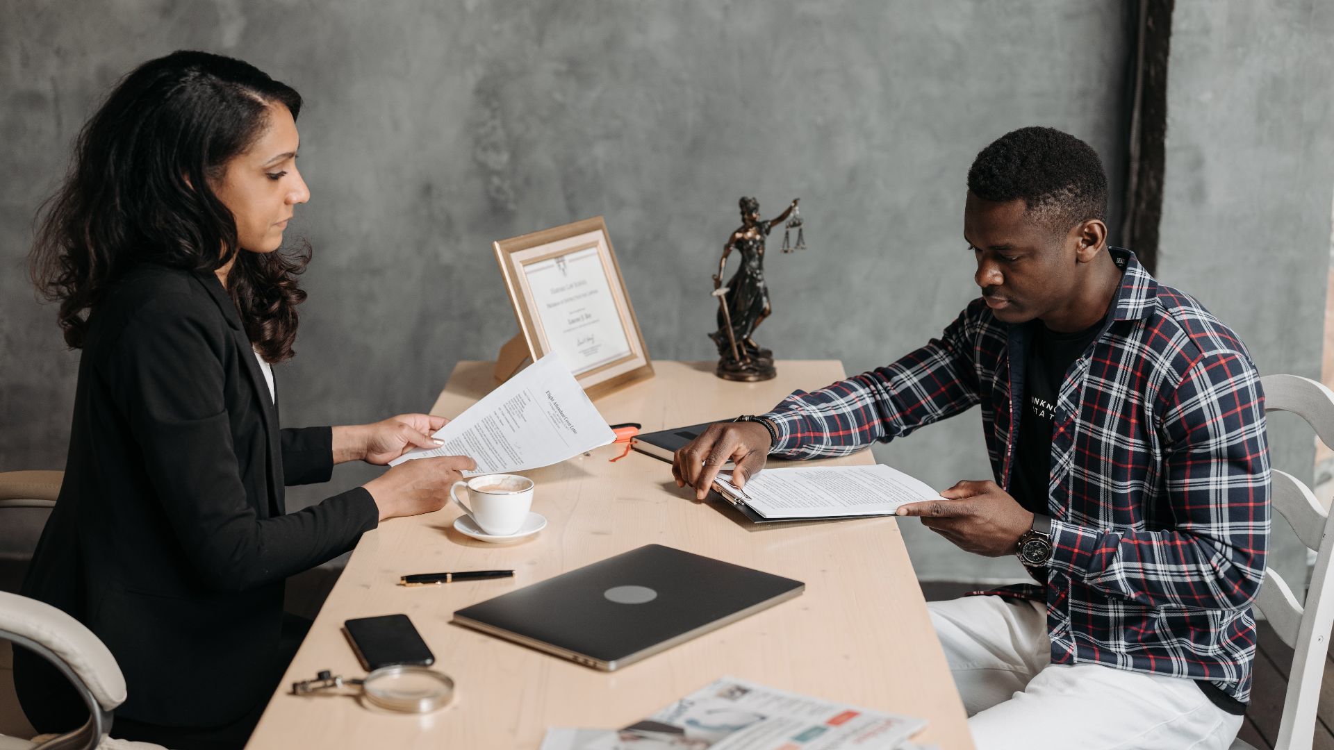 Business professionals discussing documents in a modern office setting.