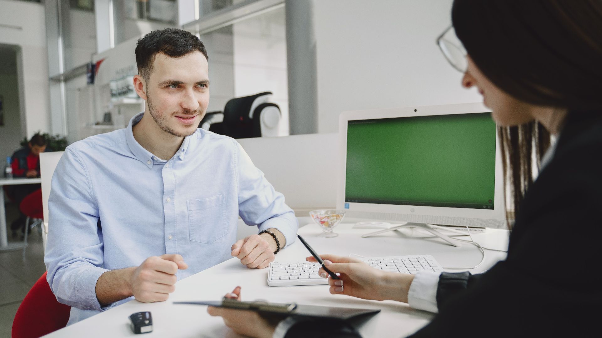 A business meeting between two office professionals, discussing strategies in a modern office.