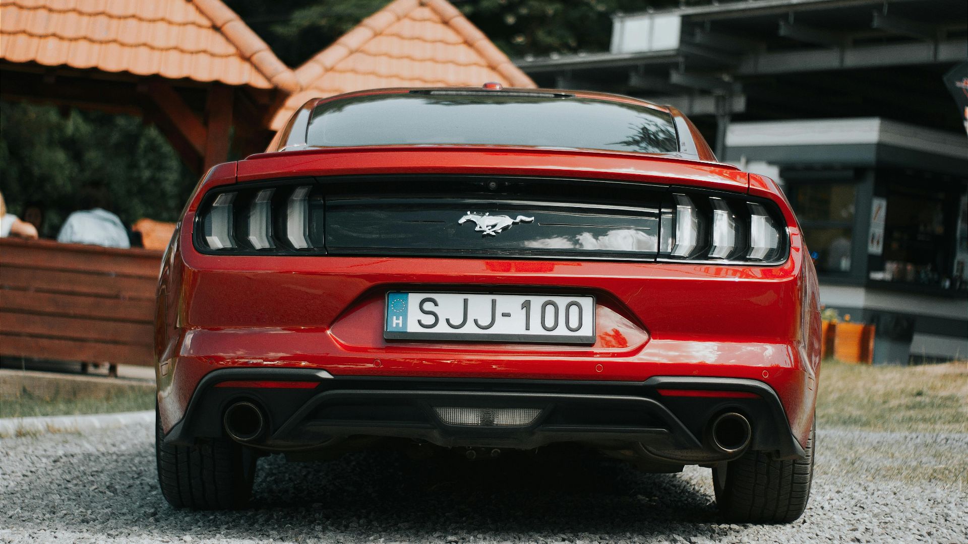 Classic red Ford Mustang parked outdoors in Hungary, showcasing rear details.