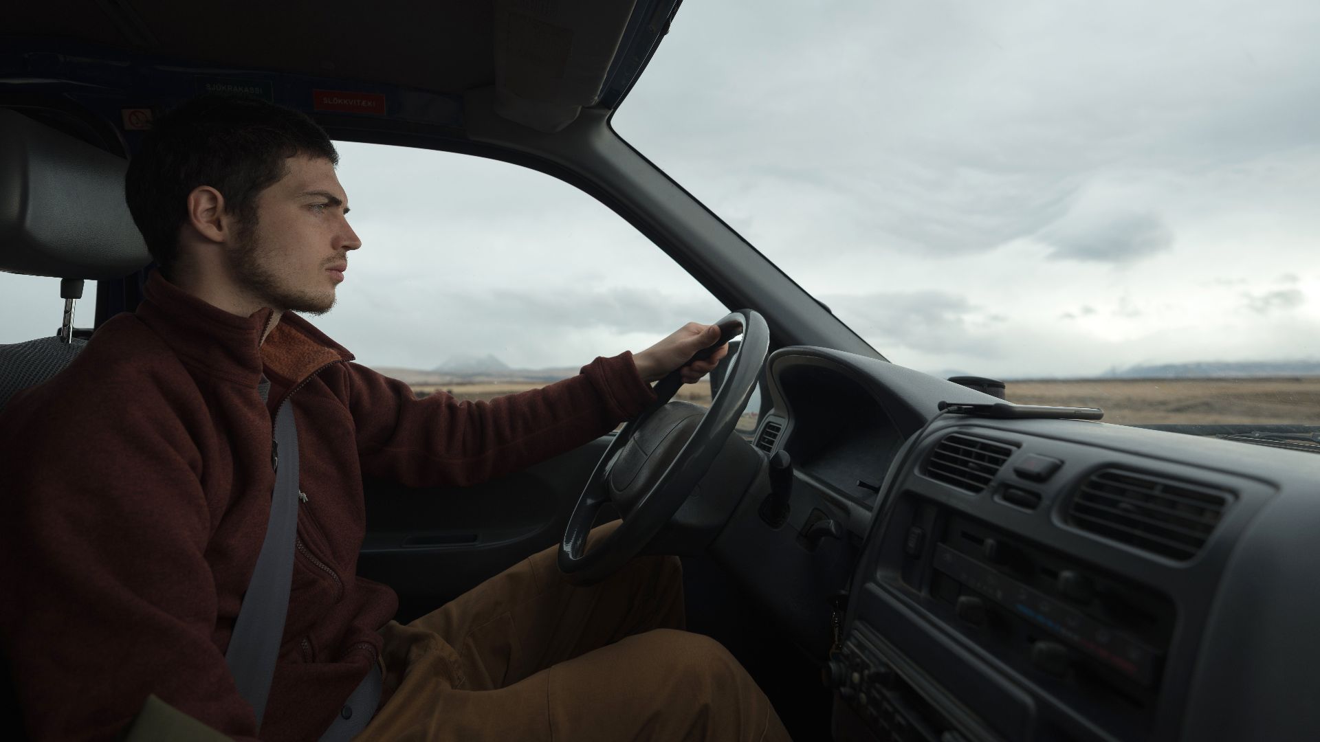 A man driving through a vast landscape, emphasizing solitude and exploration.