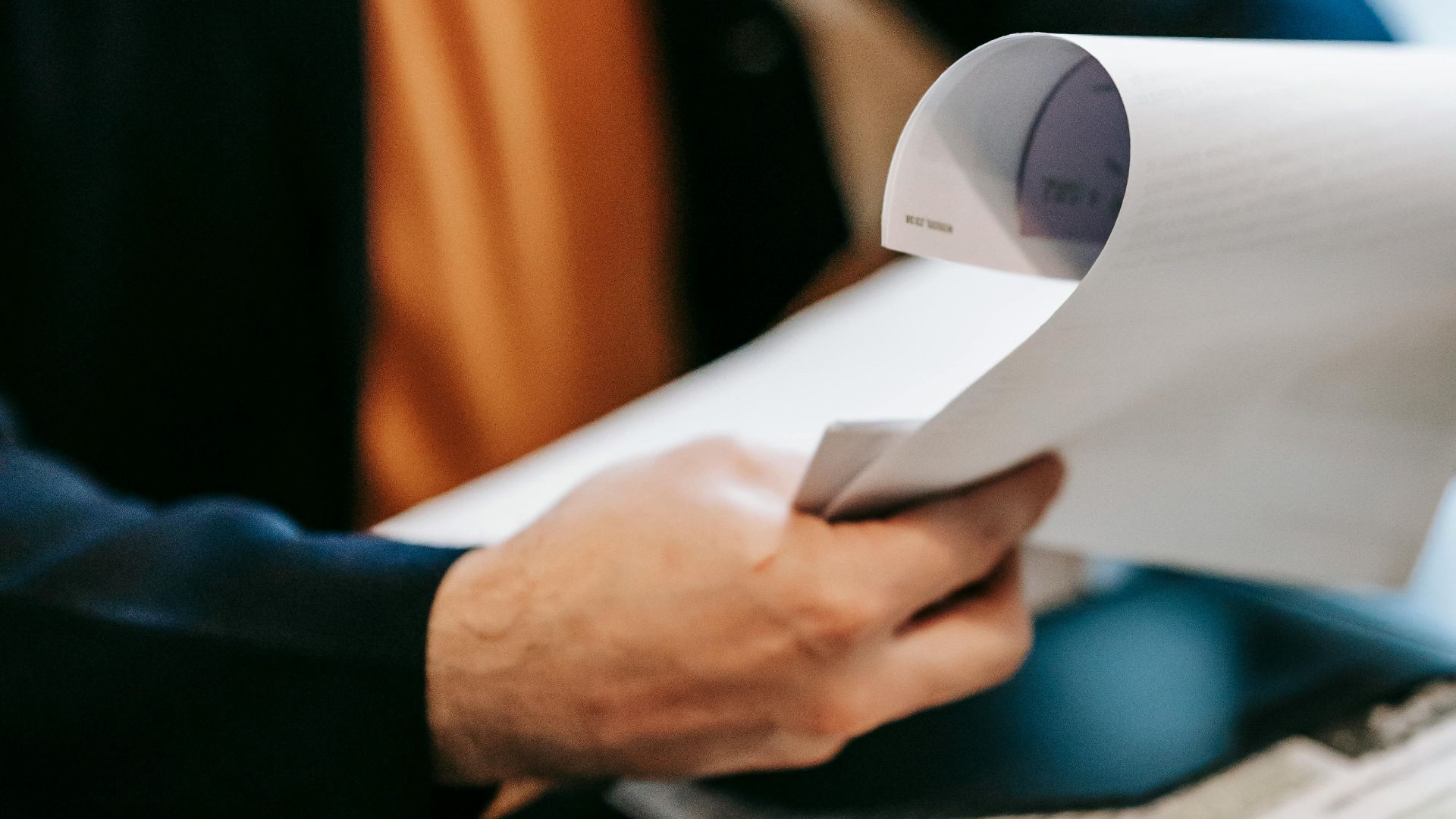 Business professional reviewing important documents indoors. Hands focus, blurred background.