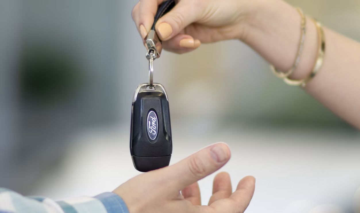 A person handing a car key to another person